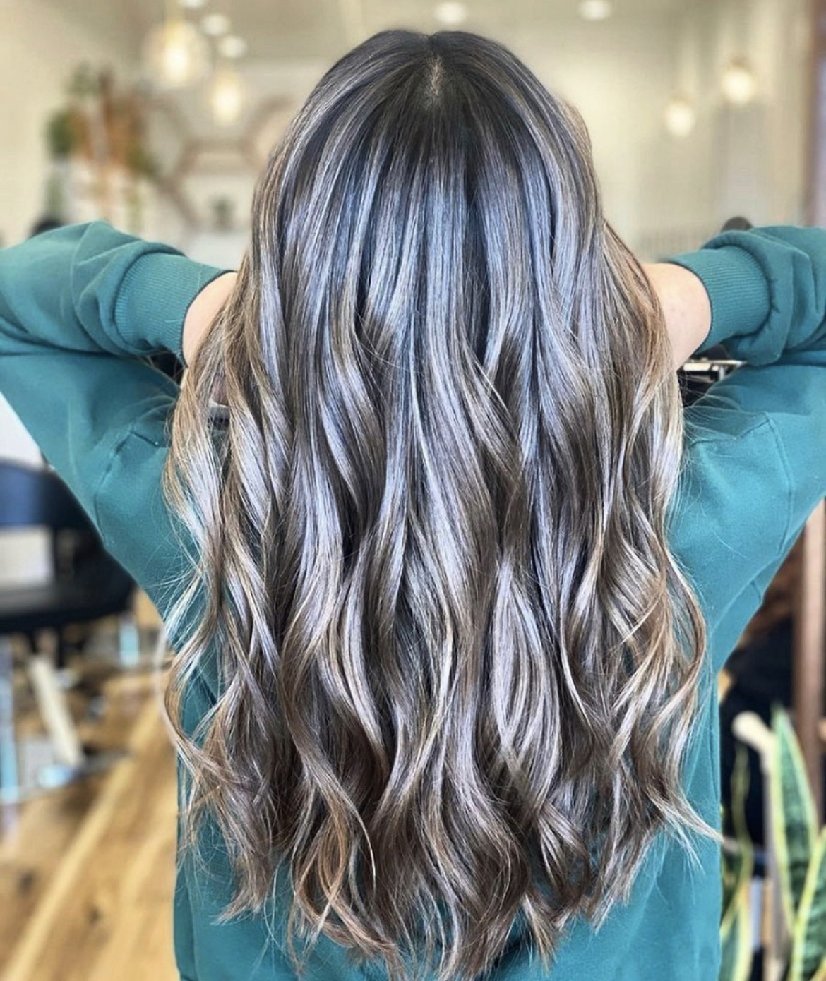 Back view of long, cool brunette hair with subtle ash highlights, styled in soft beachy waves for added texture and movement.