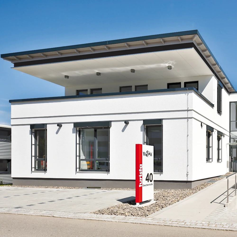 Modernes Gebäude mit auffälligem, roten Firmenschild mit Schriftzug "turista" und der Hausnummer 40.