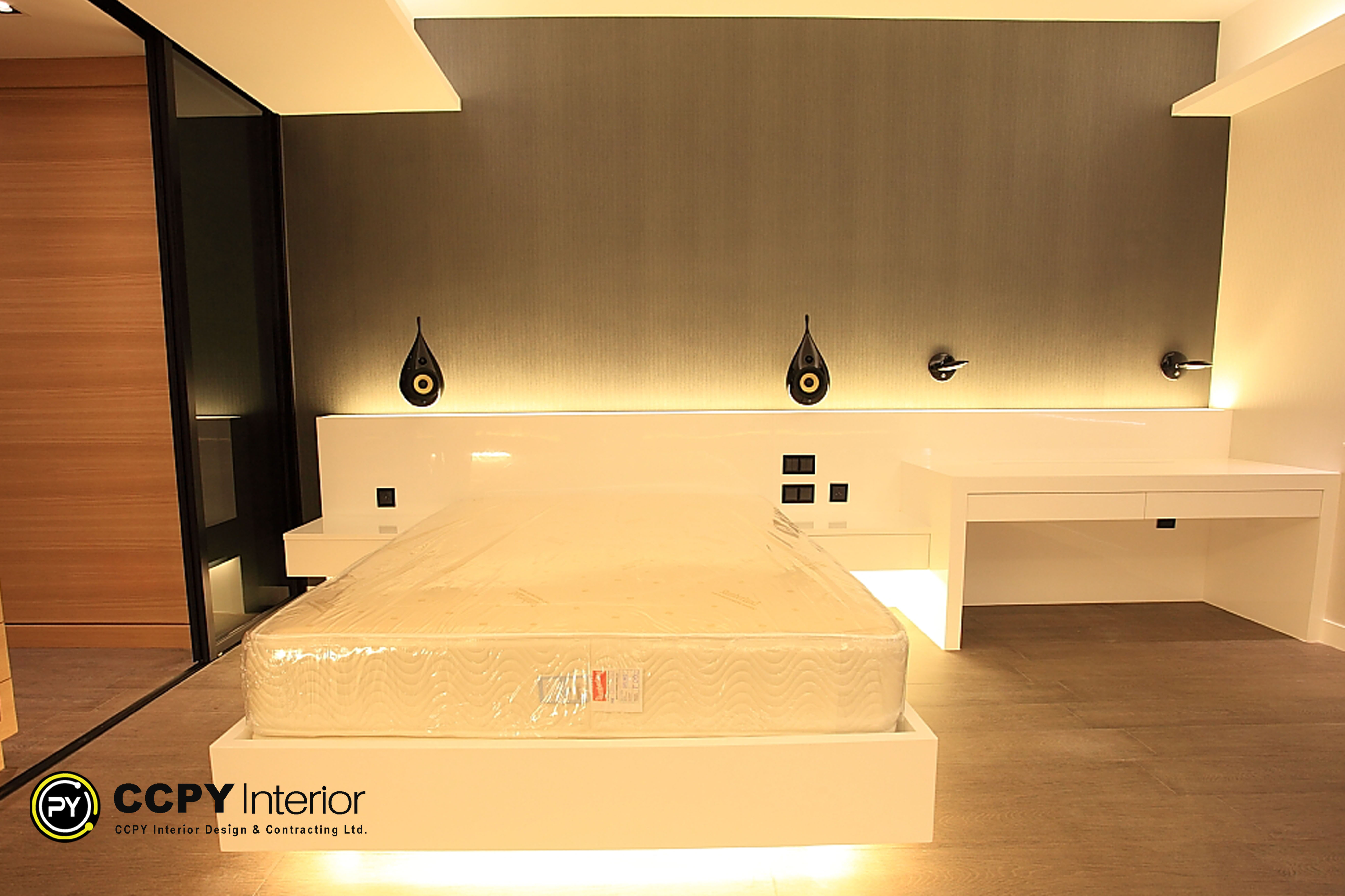 Master bedroom in Standalone House, Perkins Road featuring high-gloss white platform bed with LED under-glow, dark Farrow & Ball textured wallpaper, and teardrop Bowers & Wilkins speakers for high-fidelity audio.