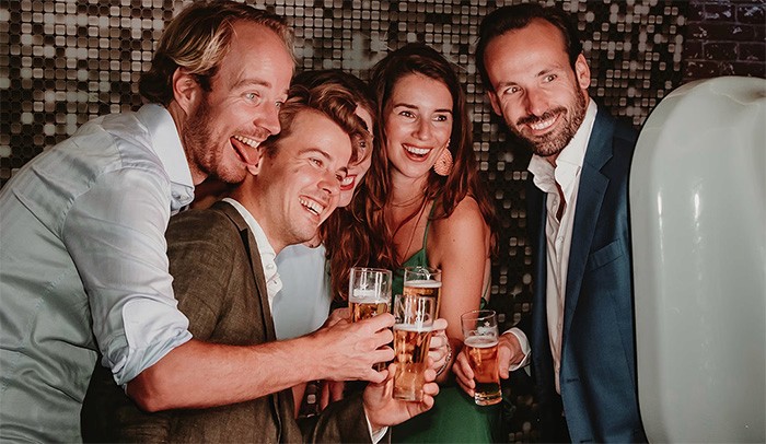 Gasten van bruiloft maken gebruik van photobooth. Lachend en proostend op de foto.