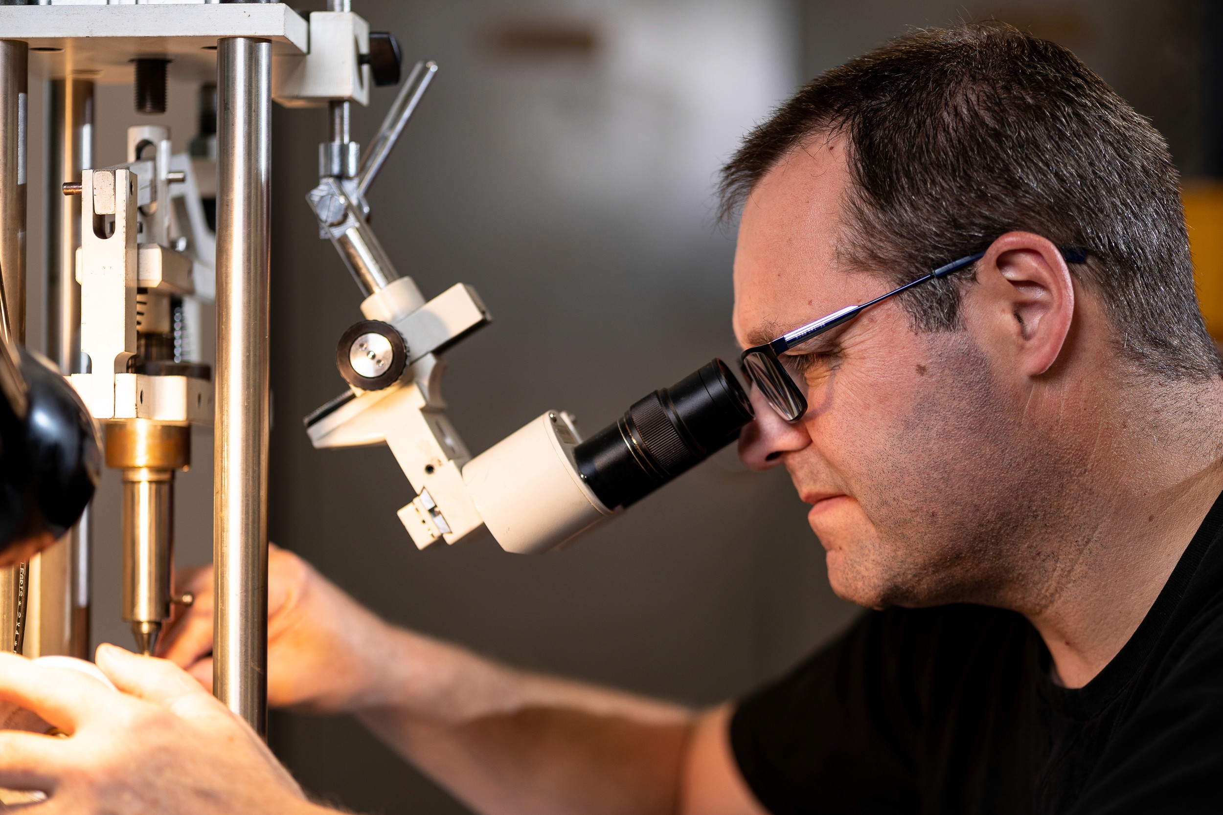 jeweller with microscope observing diamonds