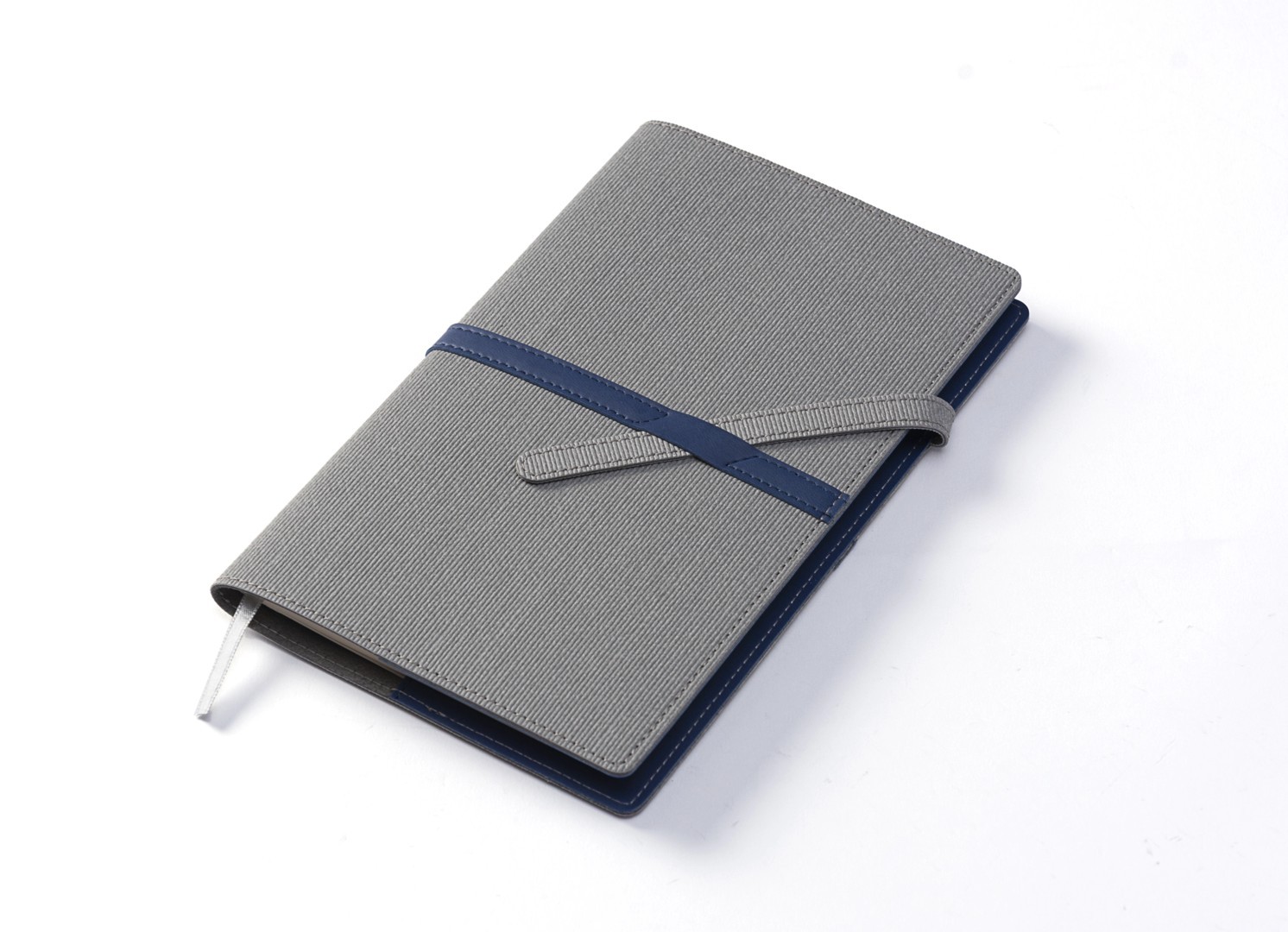 Angled view of closed notebook showing textured surface and closure mechanism.