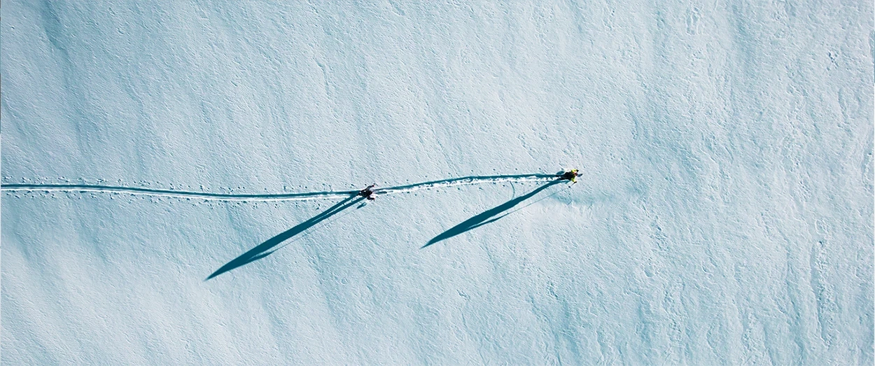 Two people walk in the snow
