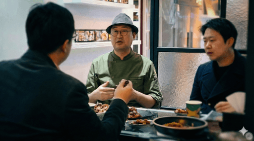 Close-up of lush, dark green leaves, some glossy and wet, against a muted background.