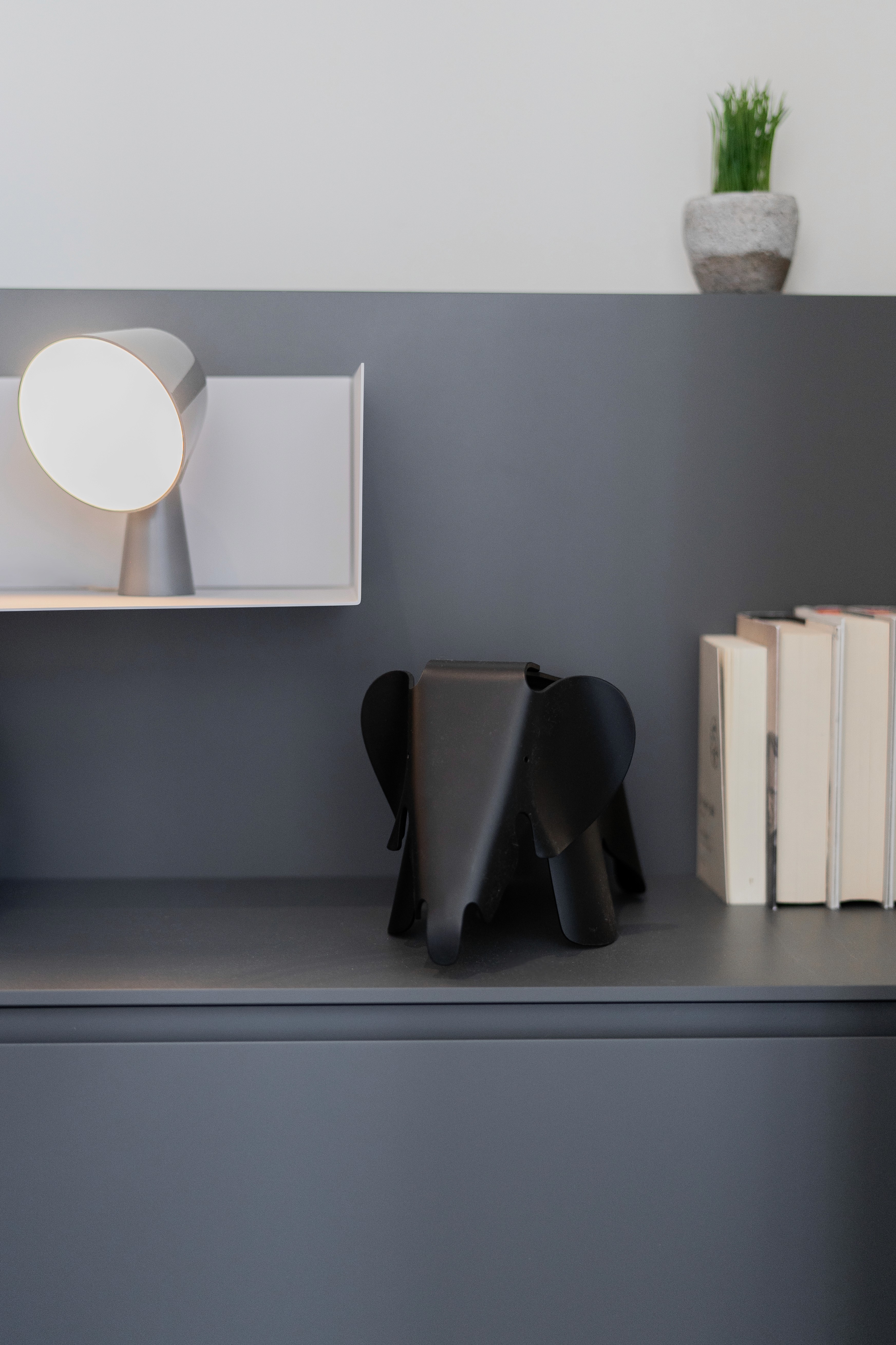 Figura Vitra Eames Elephant negra sobre mueble gris