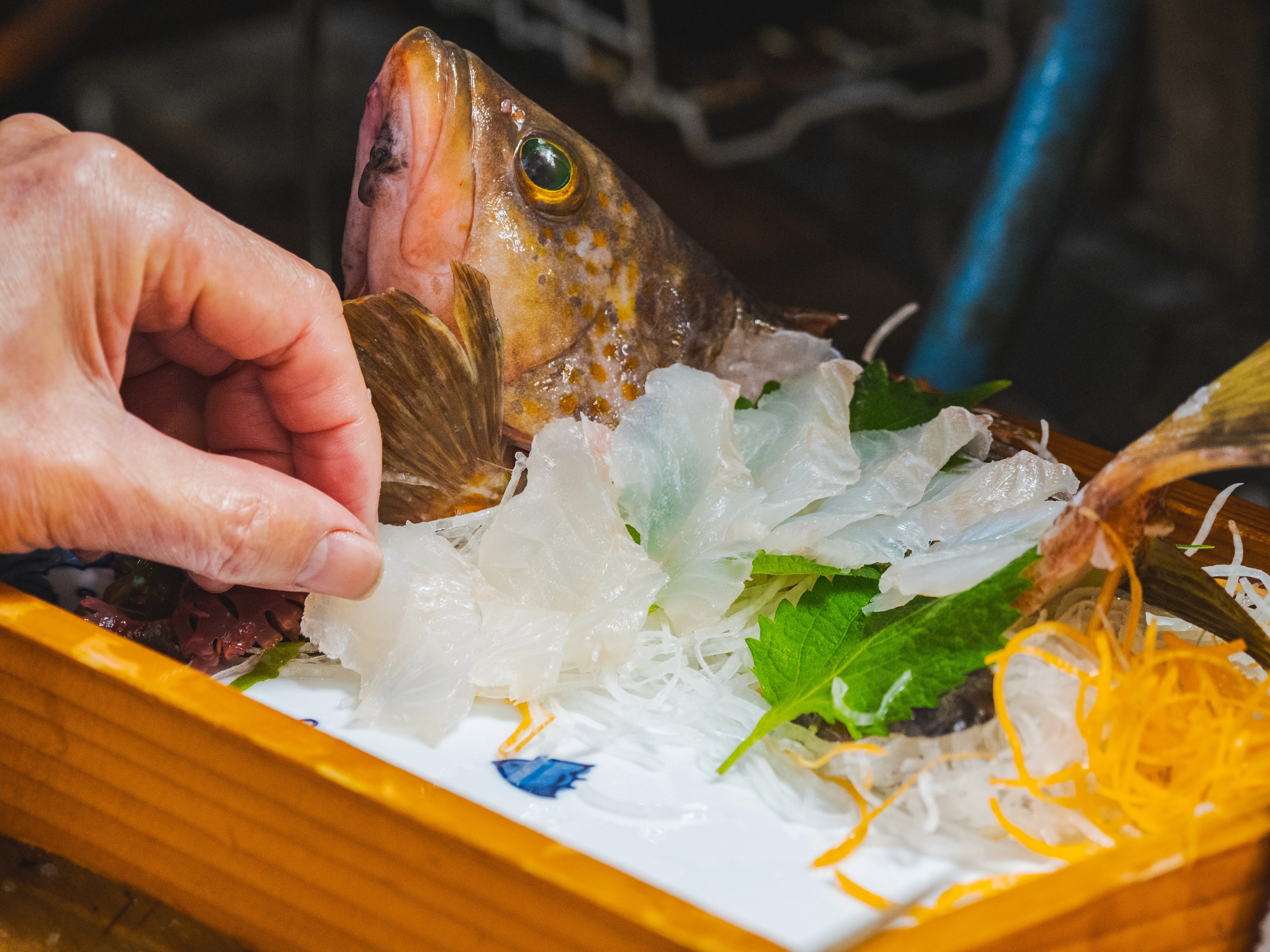 Customer picking up fresh sashimi