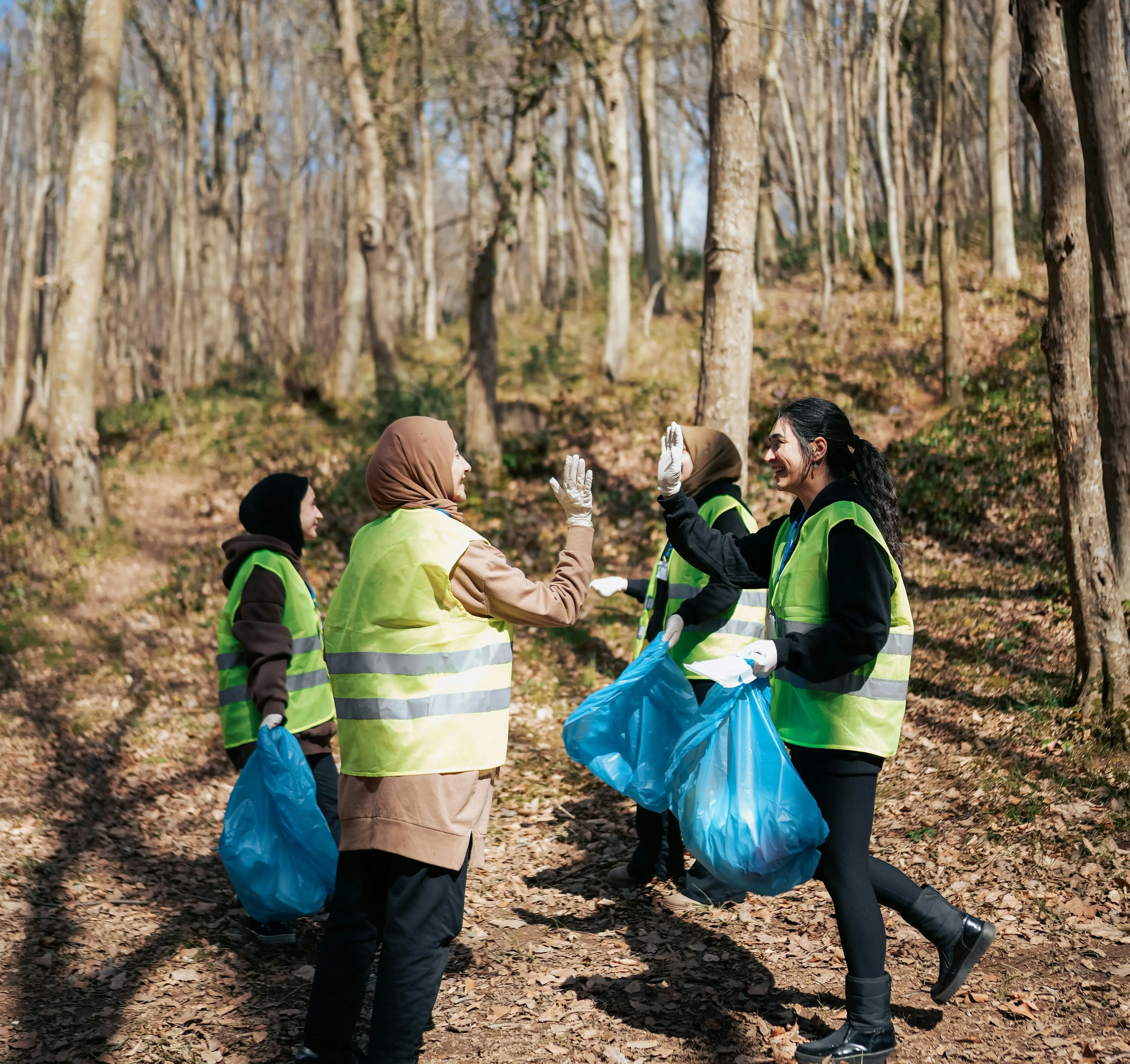 Women from diverse backgrounds cleaning the park, looking happy and working as a team.