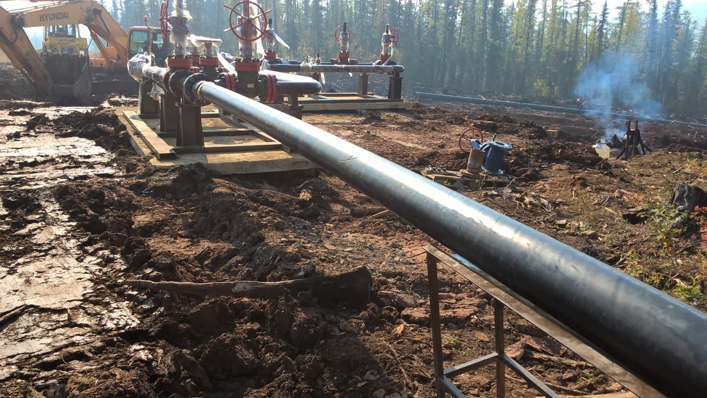 a woman sitting at a table with two laptops