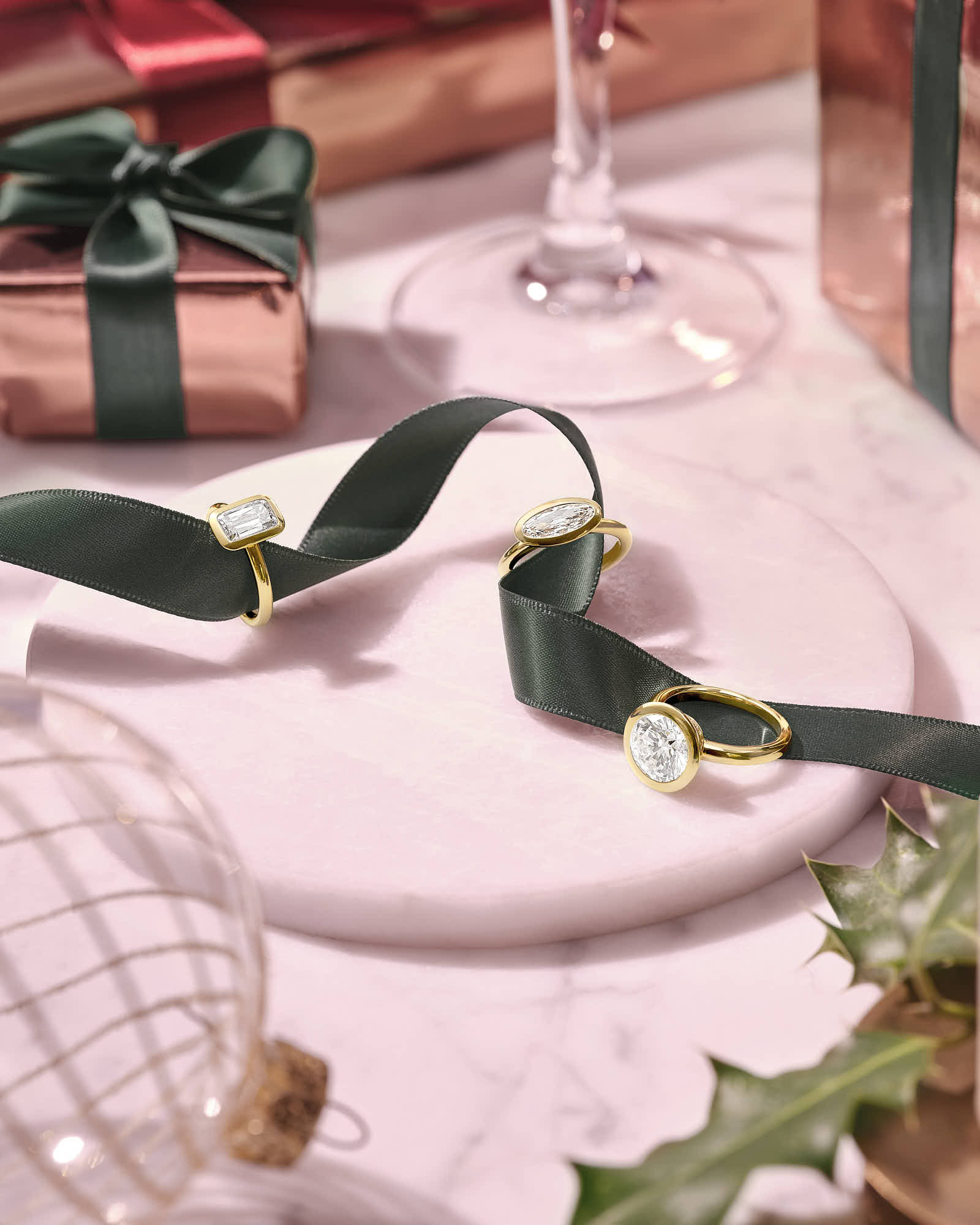 An elegant table setting with a pink tablecloth, a glass, a decorative plate, and intricate cutlery.