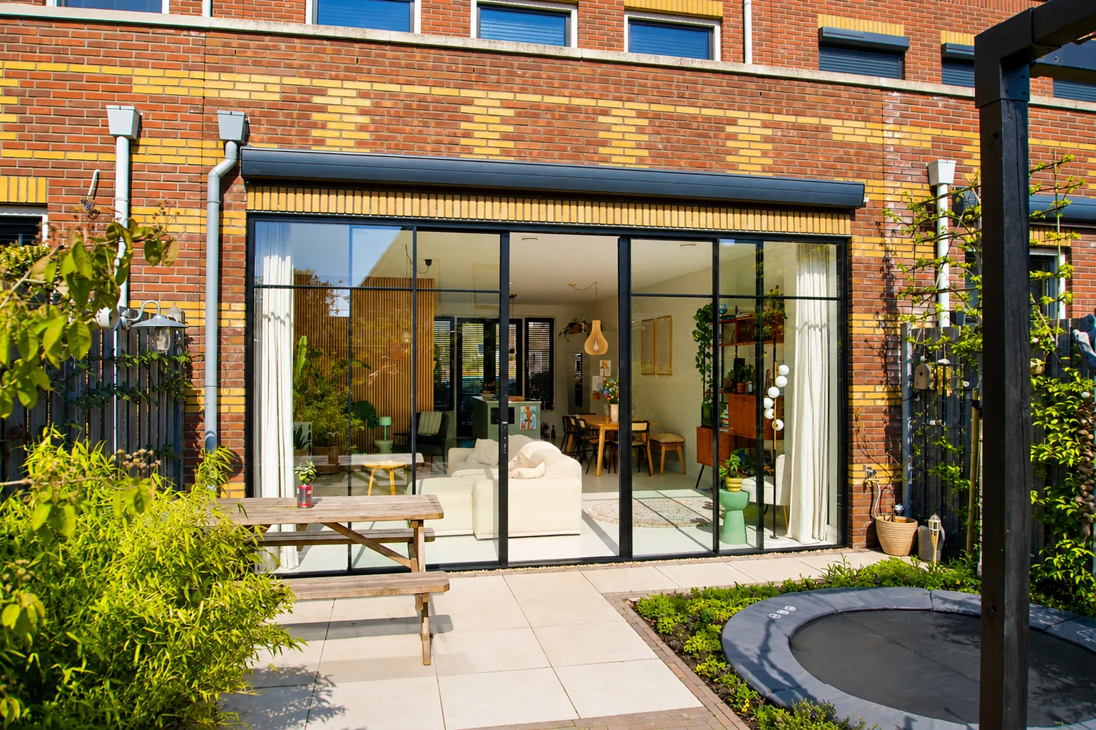 Moderne uitbouw met zwarte kunststof schuifpui aan de Thomas Mannsingel in Den Haag