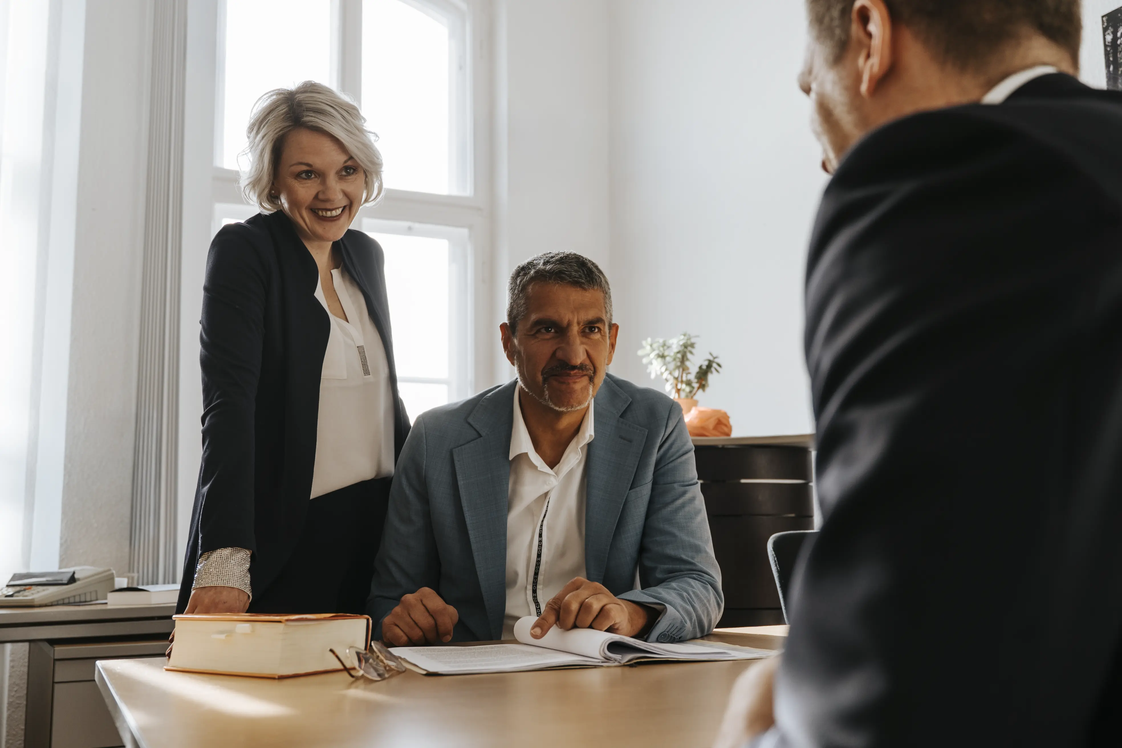 Beratungsgespräch in der Kanzlei Schick & Kollegen: Anwälte im Gespräch mit Mandant am Besprechungstisch.