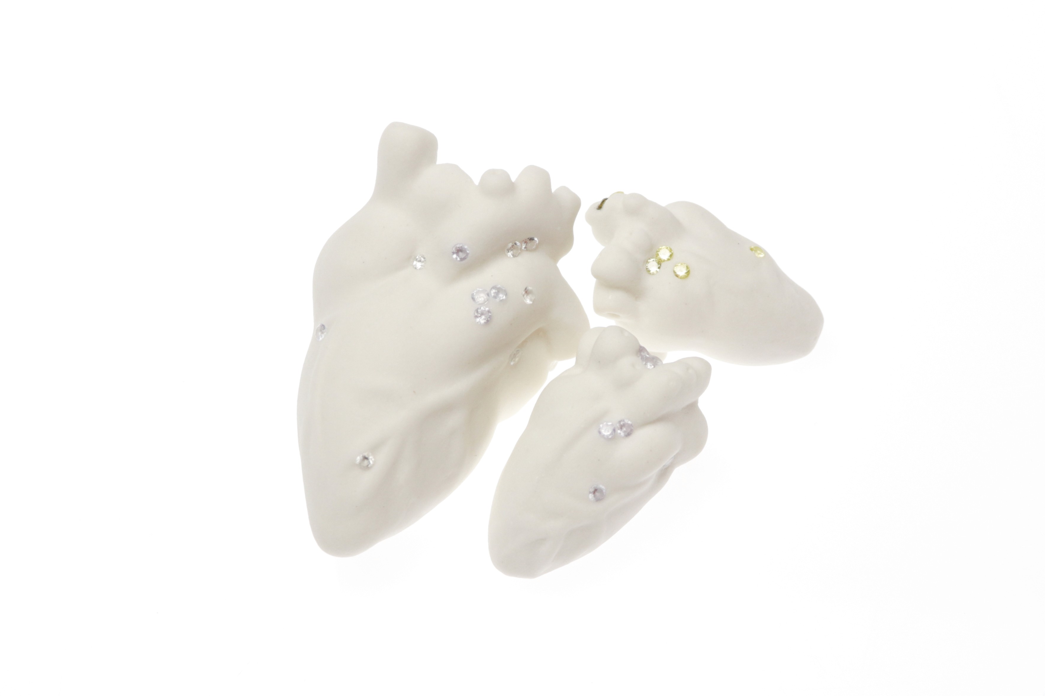 Individual view of a unique ceramic heart from Perfect Imperfection series by Yuxin Song. Highlighting cracks with cubic zirconia and mica powder. Light-up sculpture made with resin, 2022.