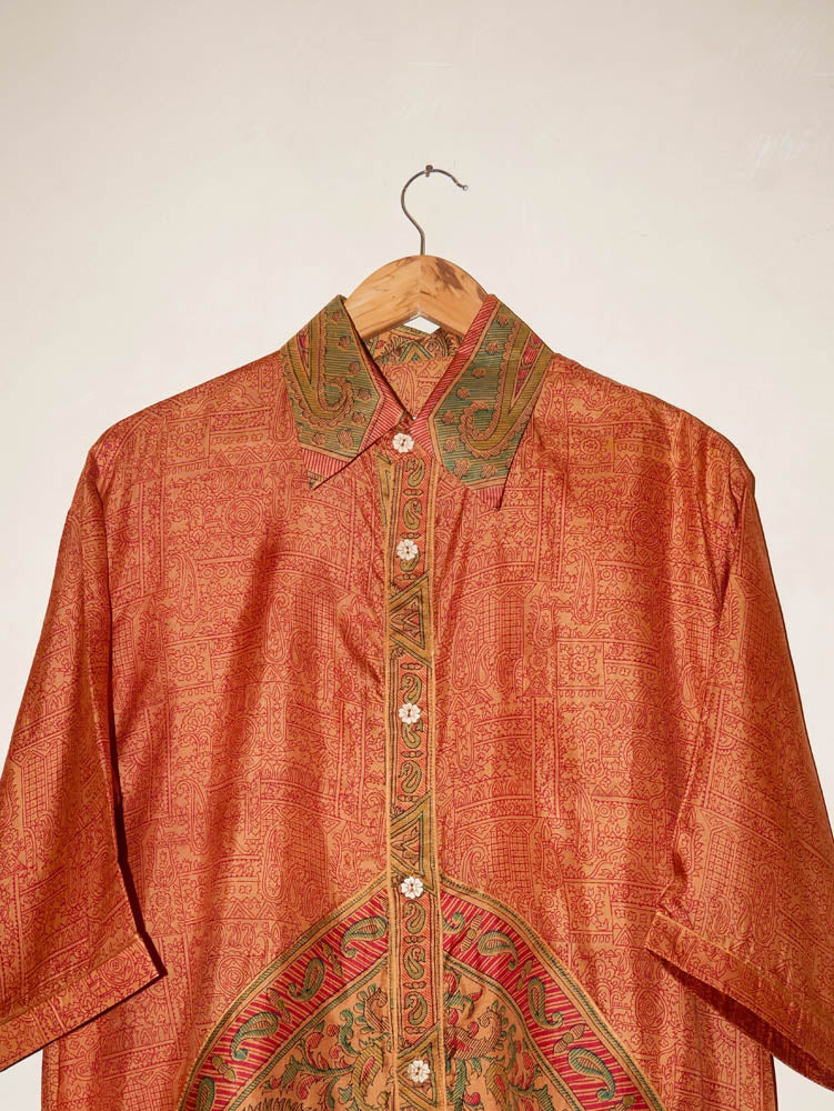 RAGA VII is a one-of-a-kind half-sleeve shirt, crafted from vintage fabric in a bold orange print with a detailed button placket, classic collar, and unique back detail.