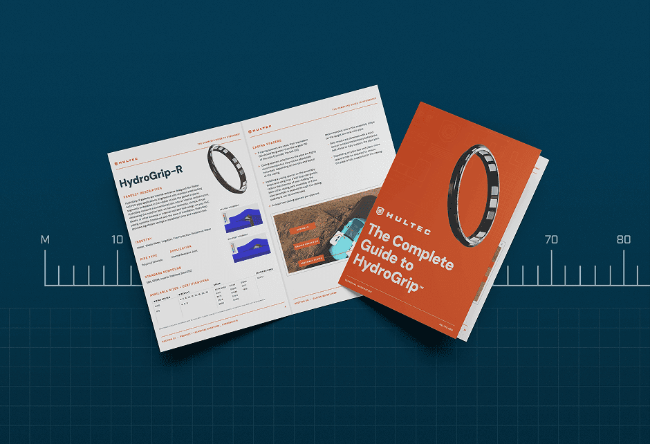 An open booklet and its cover titled The Complete Guide to HydroGrip are displayed on a blue background with grid lines and a centimeter scale.