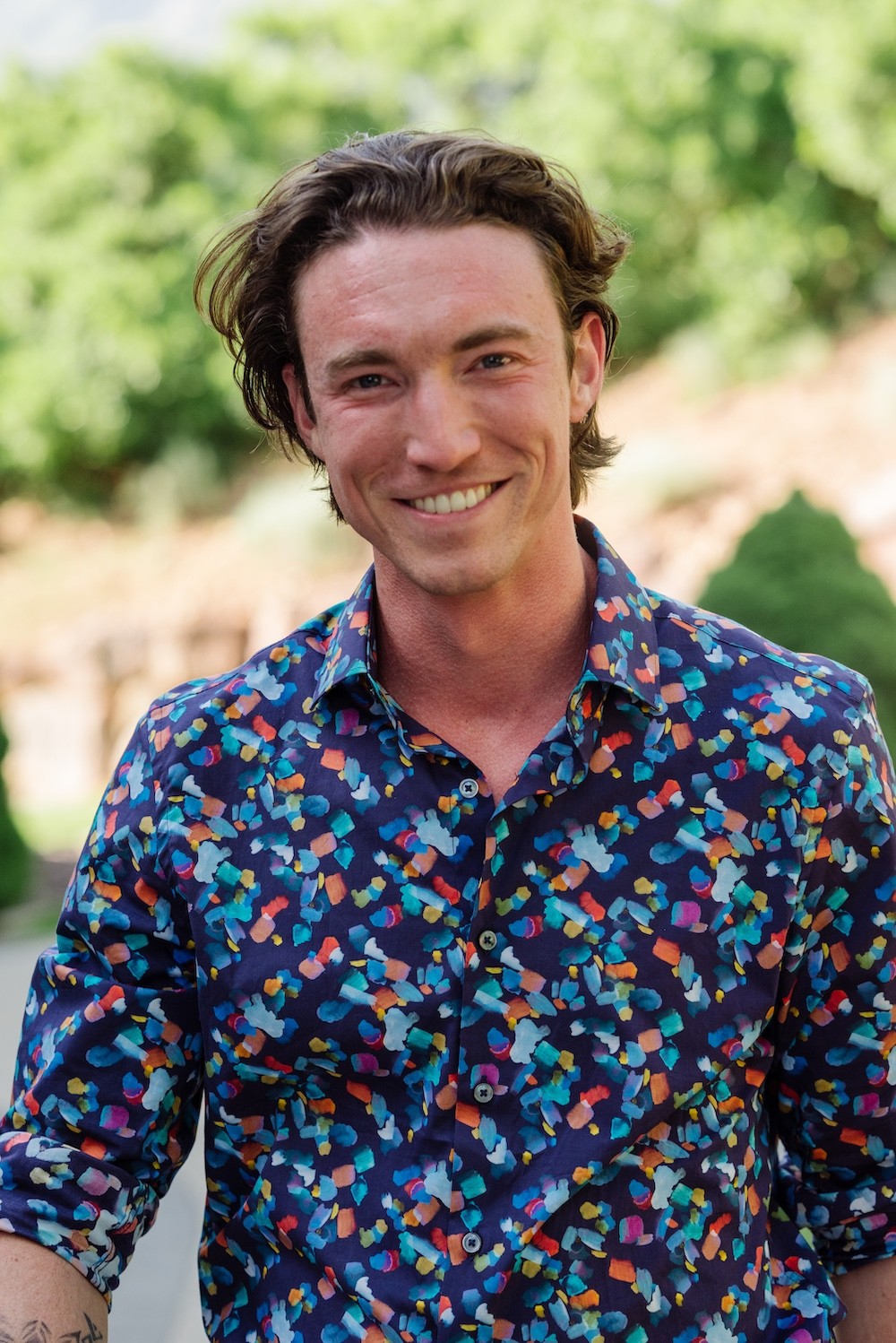 Portrait of a laughing person with curly hair wearing a white shirt