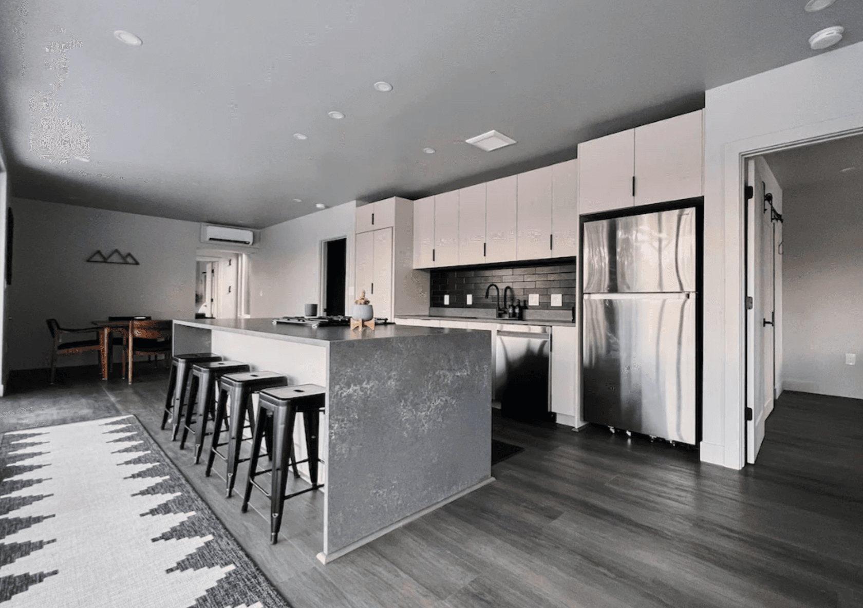 Large kitchen with all stainless steel applicances and gray vinyl floors.