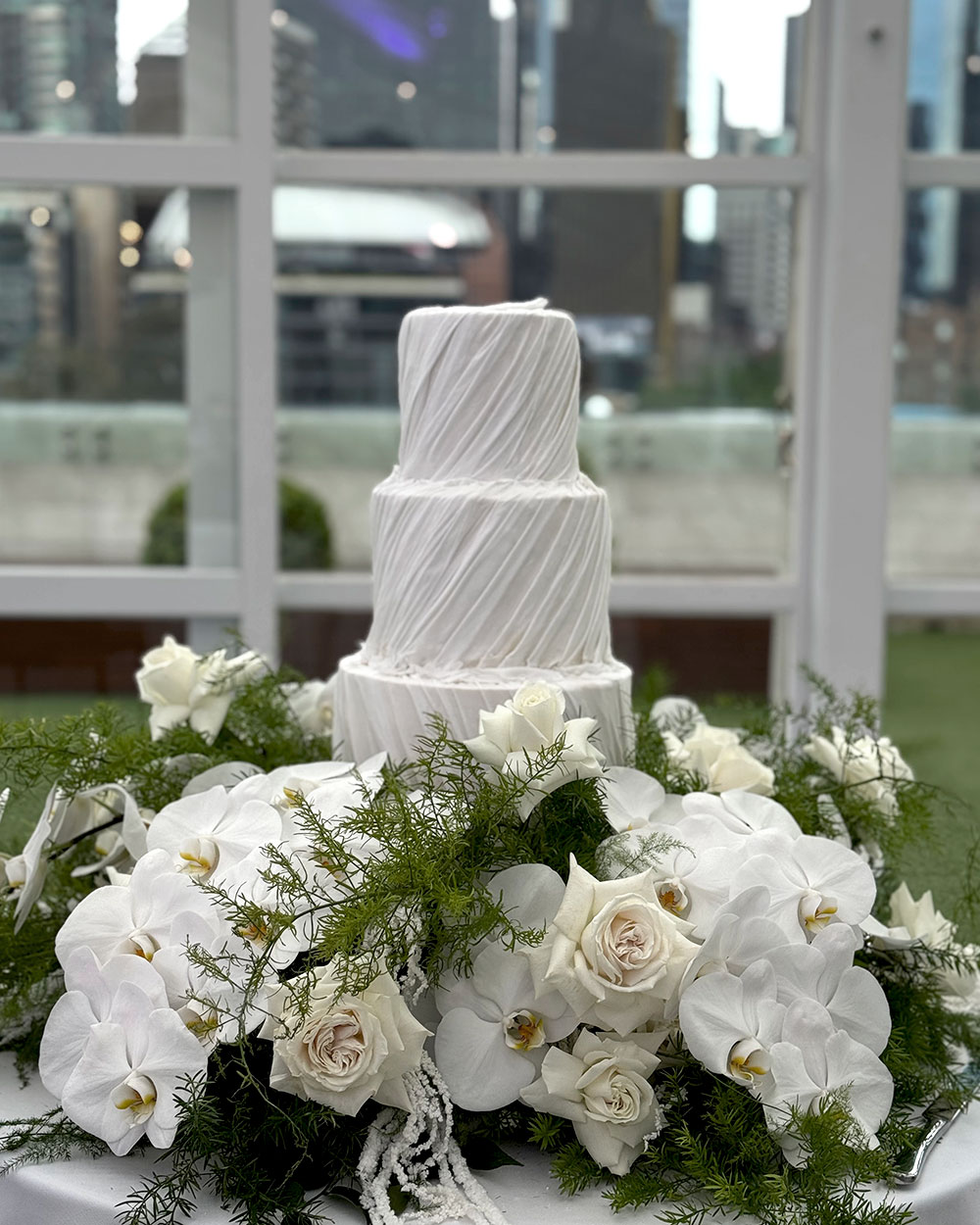couple sharing kiss with two tier vintage wedding cake with cherries.