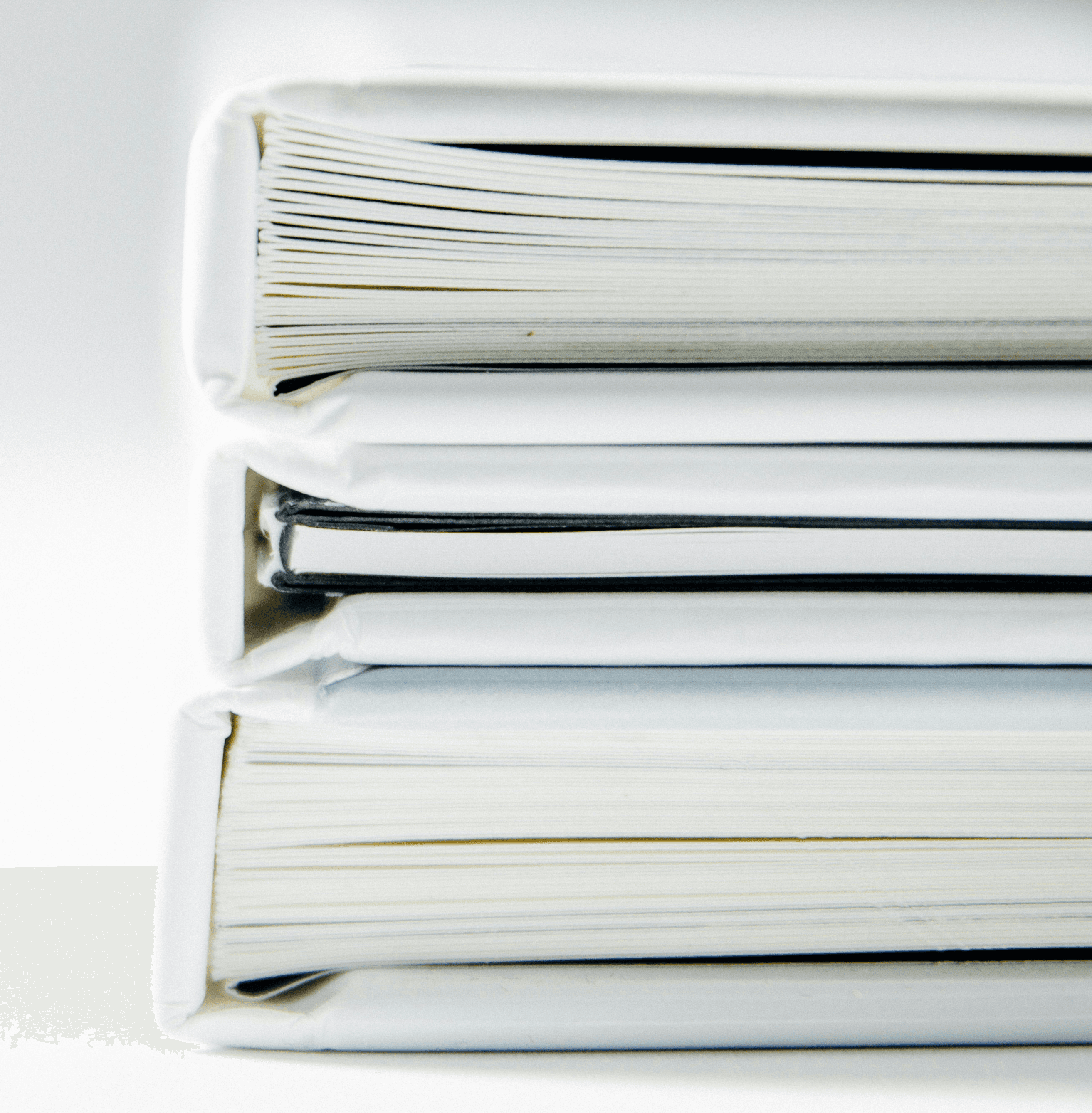 A stack of thick folders on a white surface