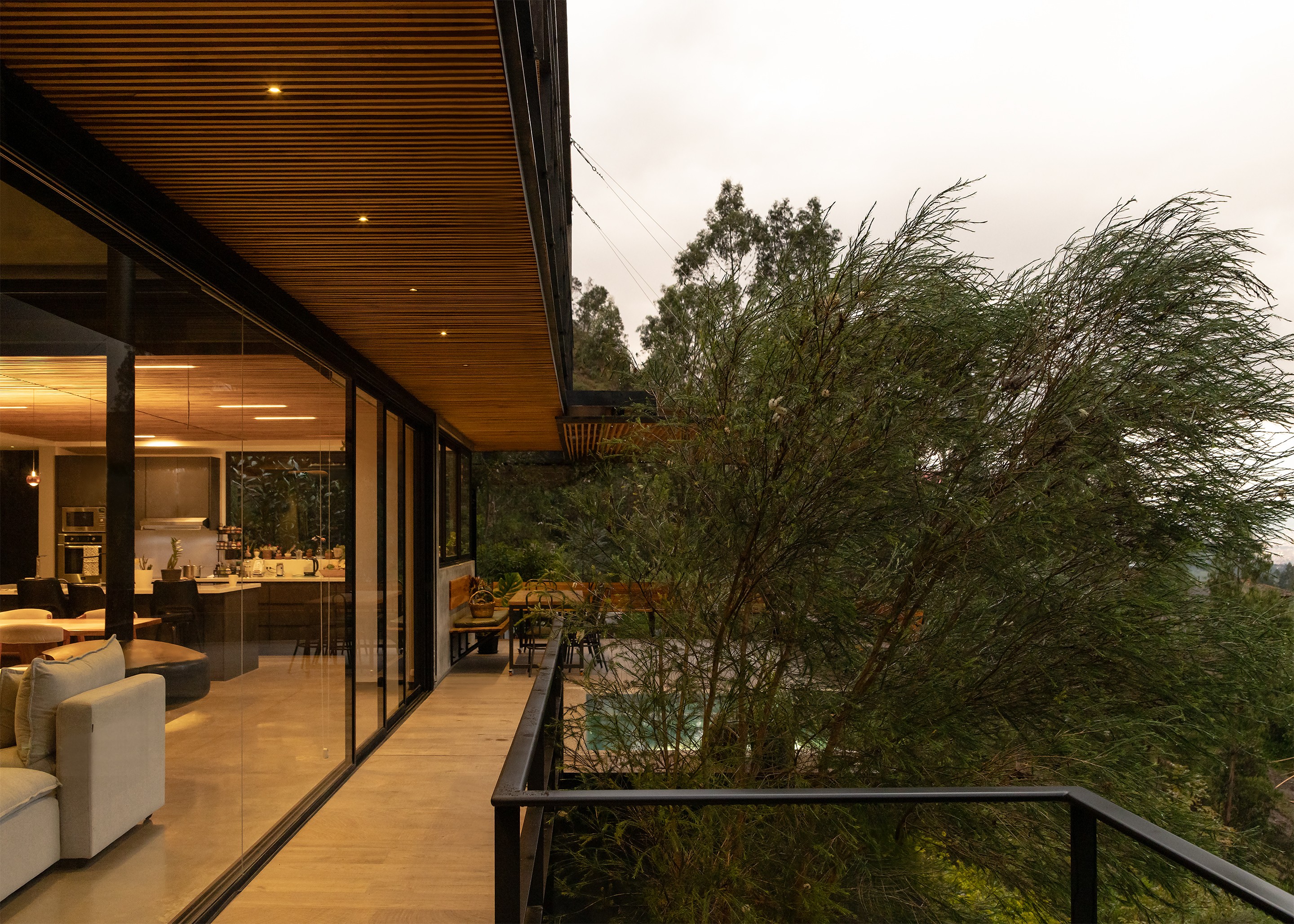 Pasillo exterior de casa moderna con cielo raso de madera 