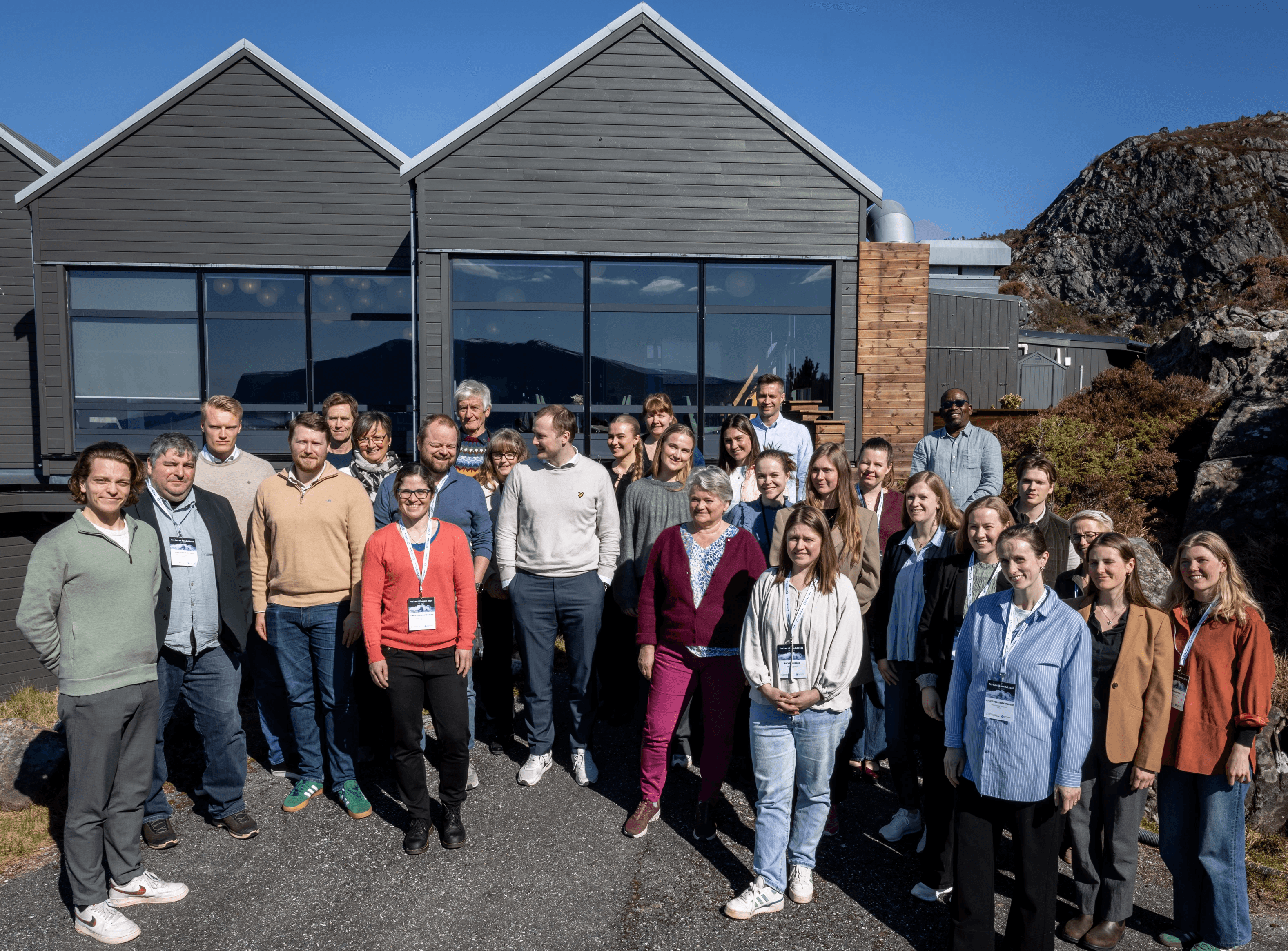 A person wearing a virtual reality headset stands in front of multiple screens, engaged in a digital experience.