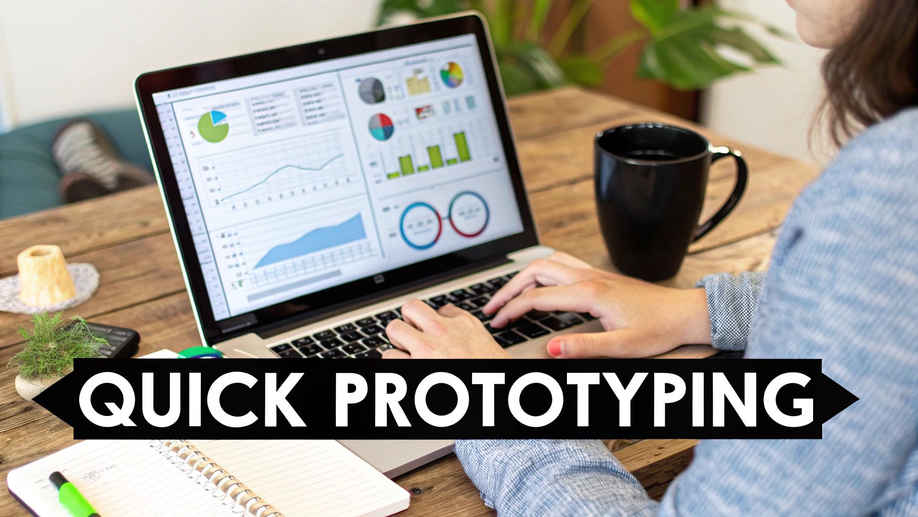 Person typing on a laptop displaying data visualizations and charts on a wooden desk with a coffee mug and notebook.