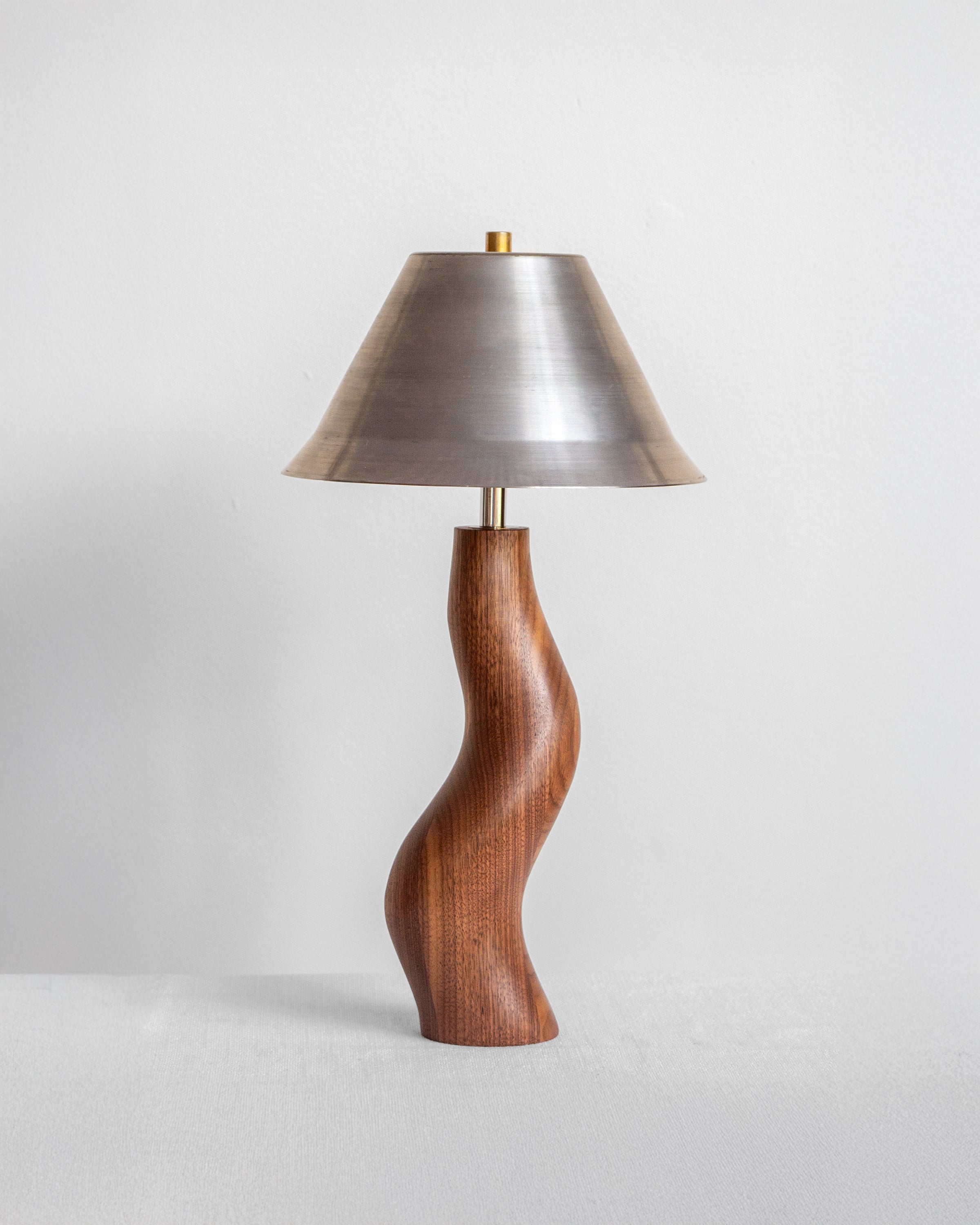 Dancing Desk Lamp with Walnut base and Raw Steel shade on a light grey background with UK, EU and US/CA wiring available on white background Wilkinson & Rivera