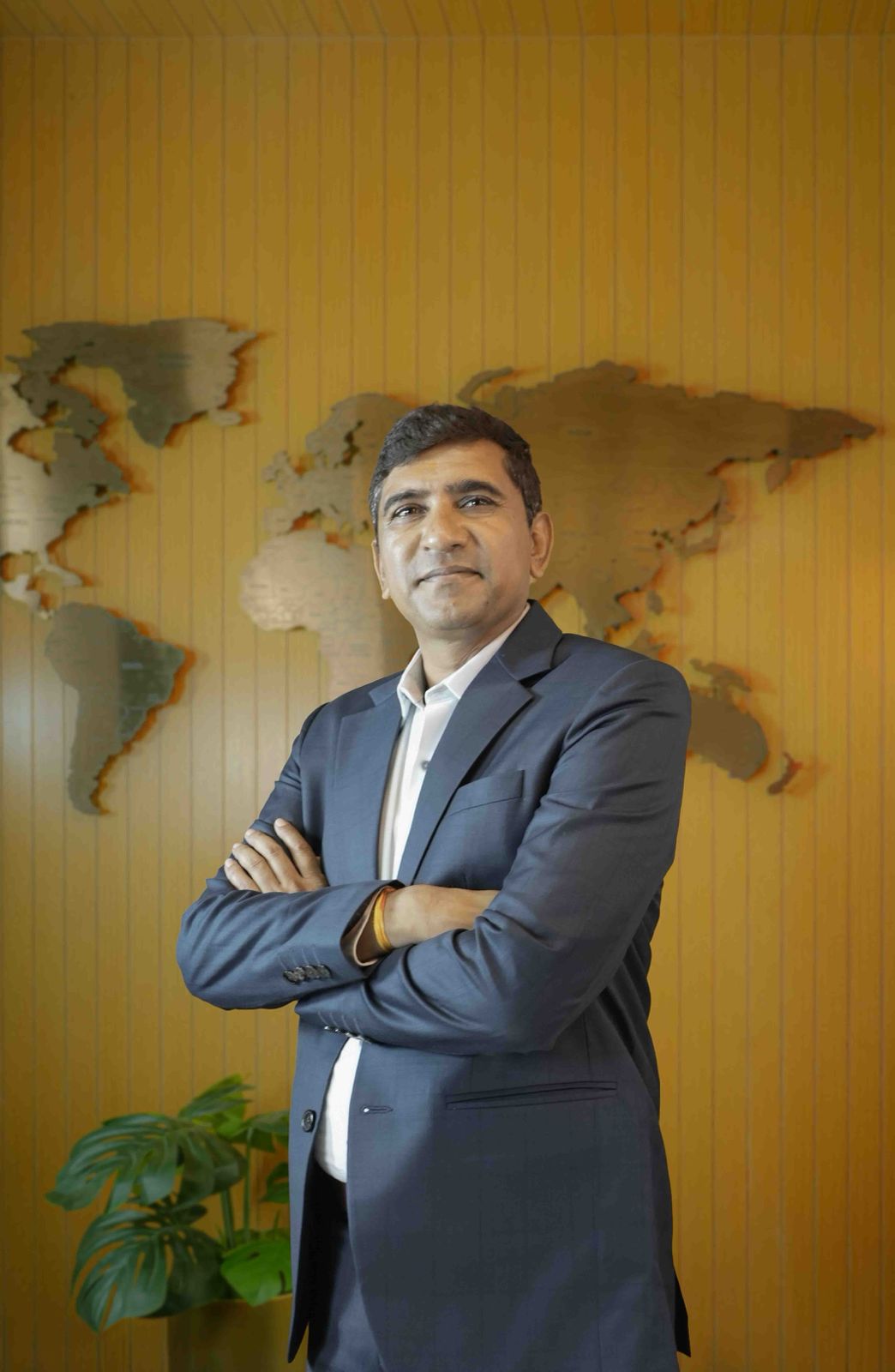 A man in a suit sits at a desk.