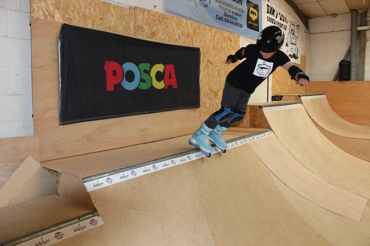 A young skater performing a trick on a rail at The Skate Farm indoor skatepark in Sussex