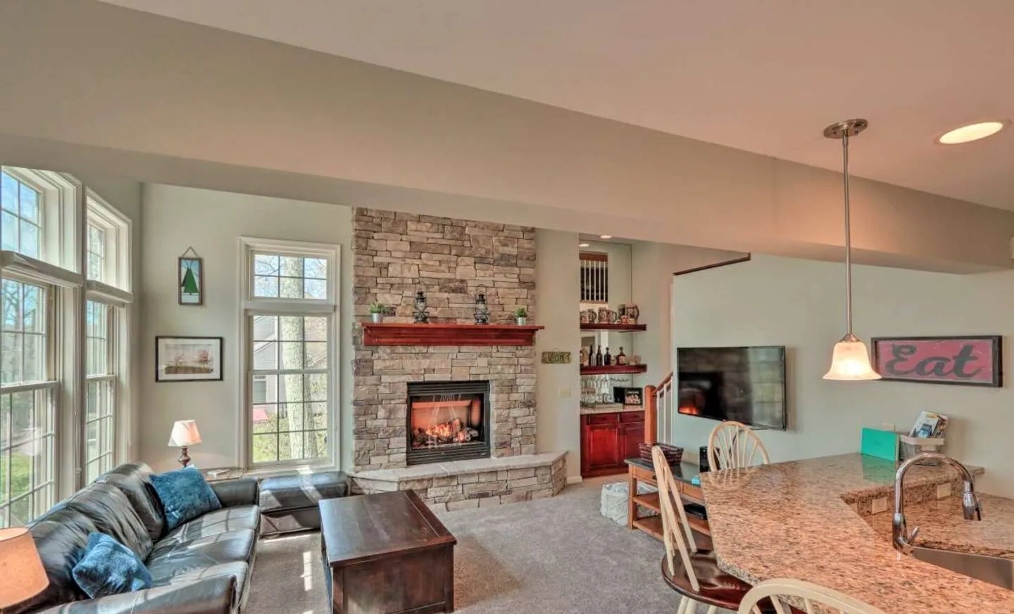 Living room with leather sofa, stone fireplace and smart TV at SummitWind