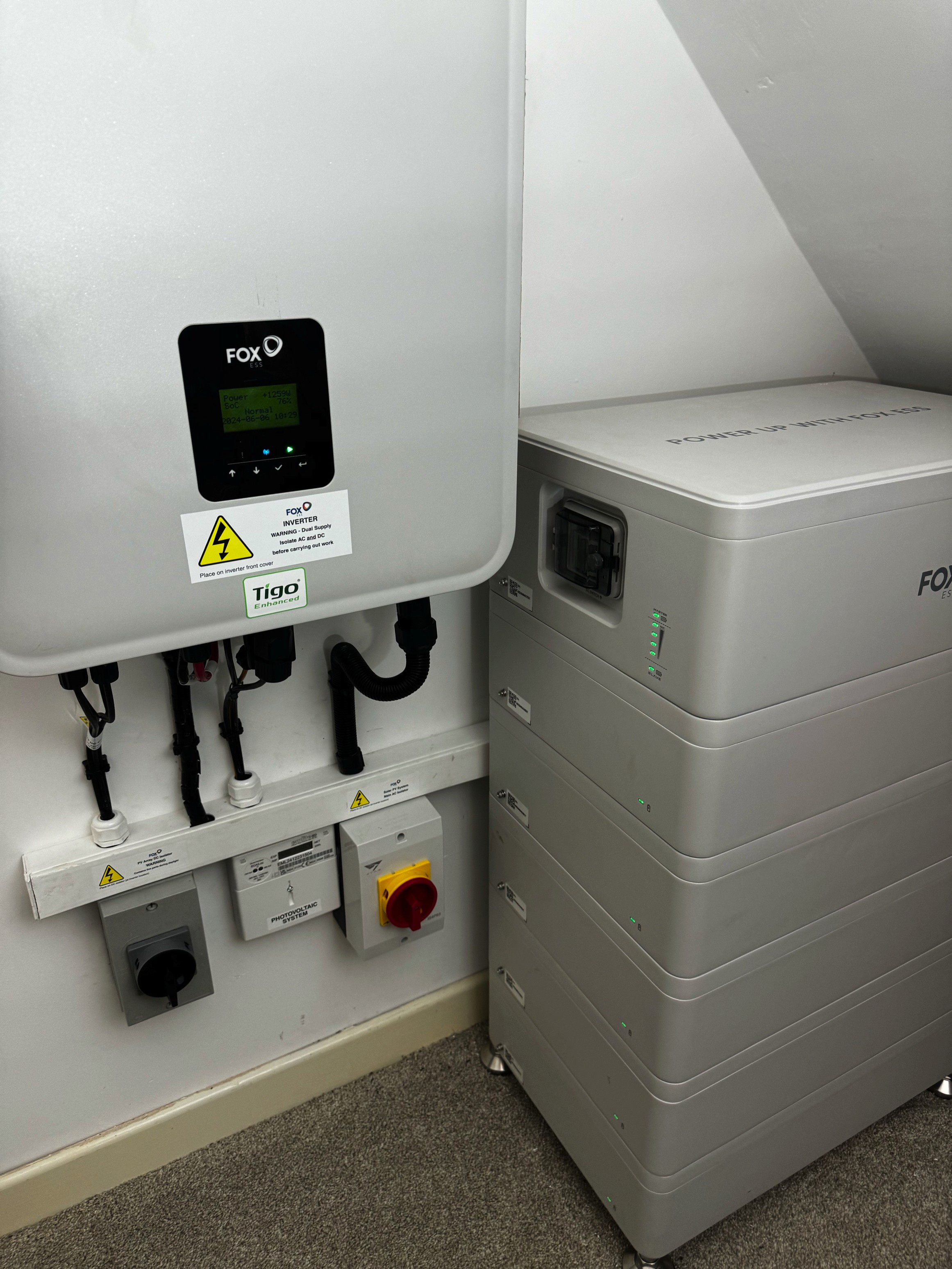 Home battery unit and wall-mounted inverter installed in a cupboard at Matt and Ali's home