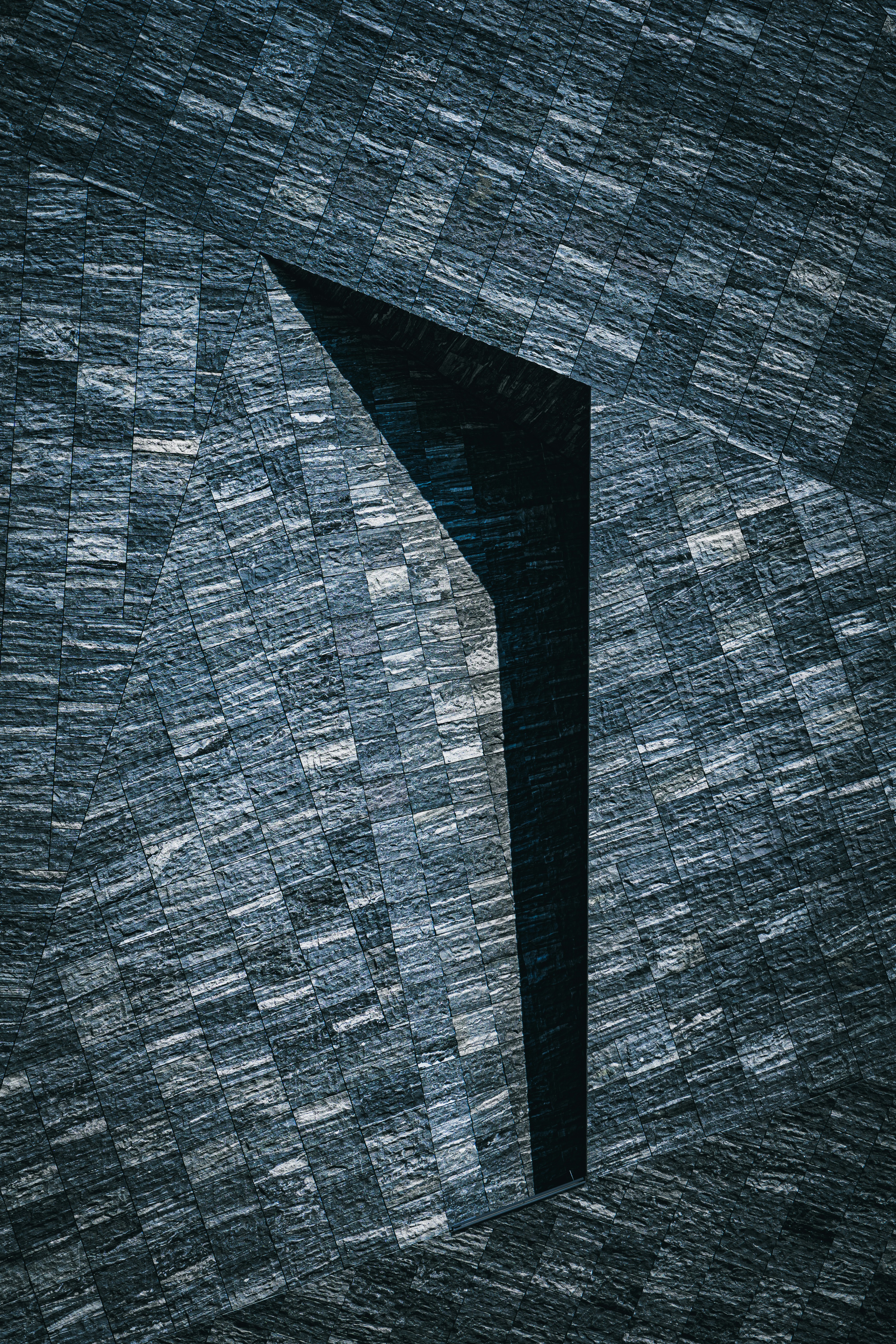 Aerial view of a winding road cutting through rocky terrain and sandy landscape.