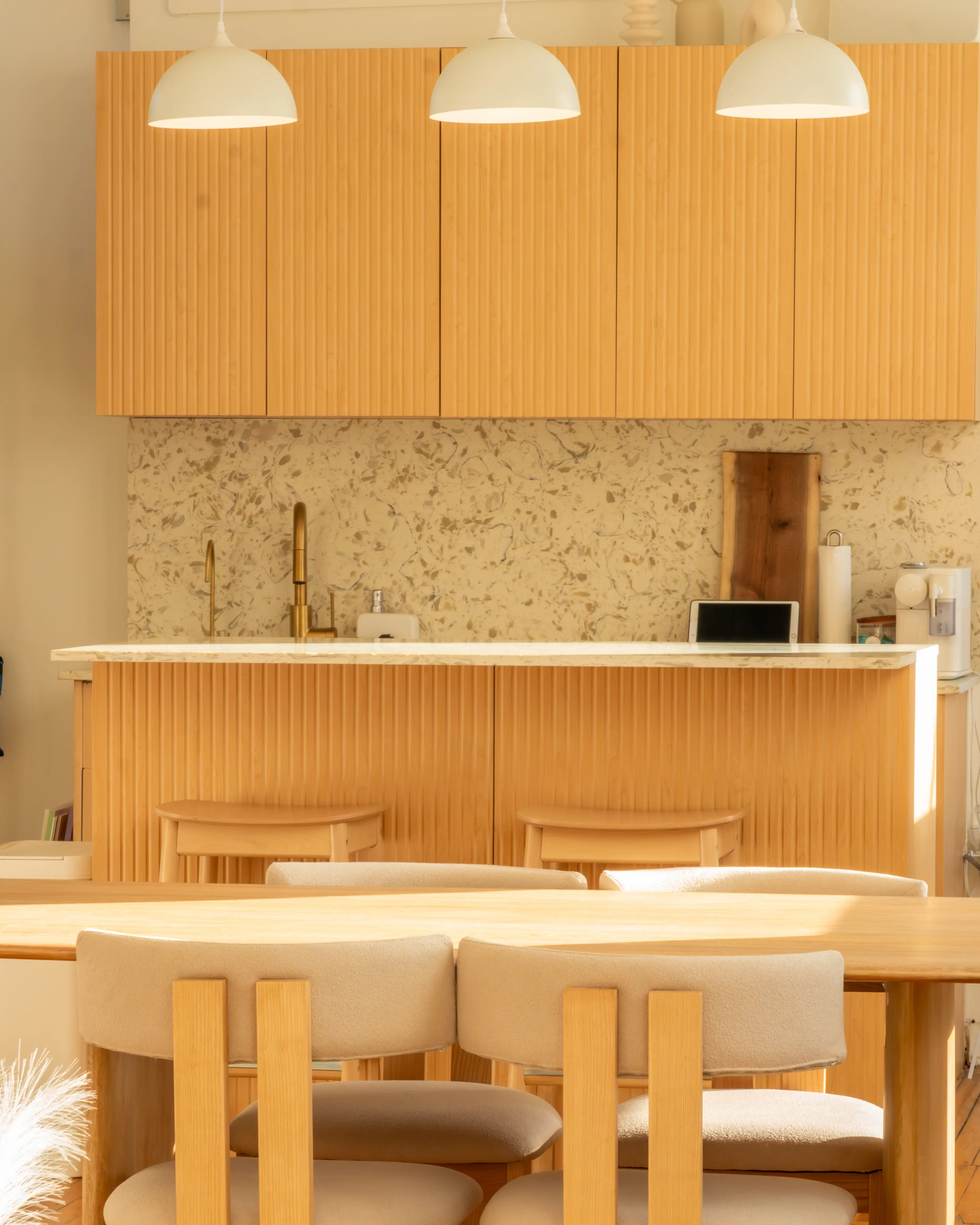 Node Studio’s semi-equipped kitchen featuring textured wooden cabinetry, a sleek countertop, modern lighting, and minimalist bar stools, offering a functional and aesthetic space for cooking content and creative projects