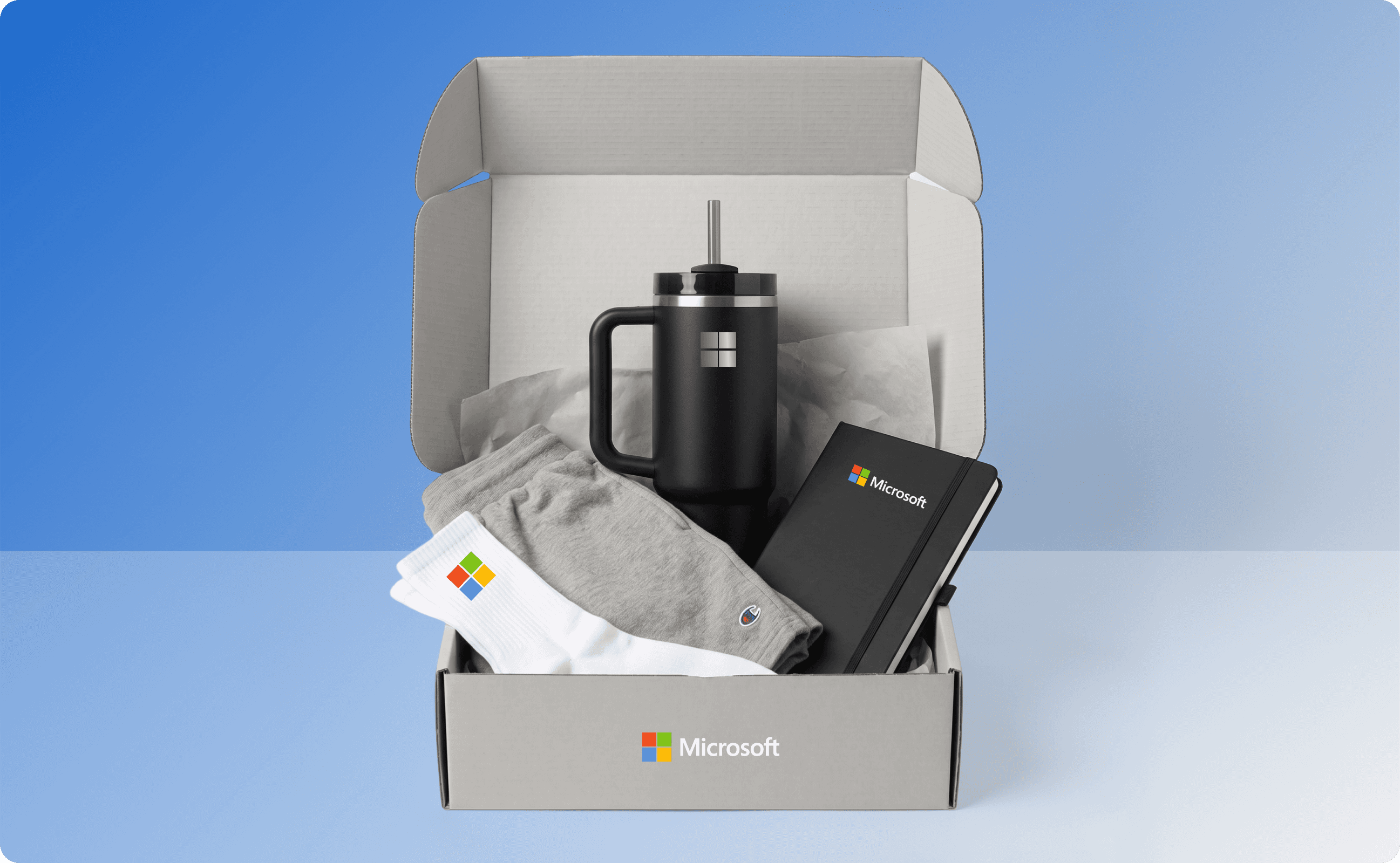Microsoft new hire swag kit that contains socks, tumbler, notebook, shorts, and apparel.