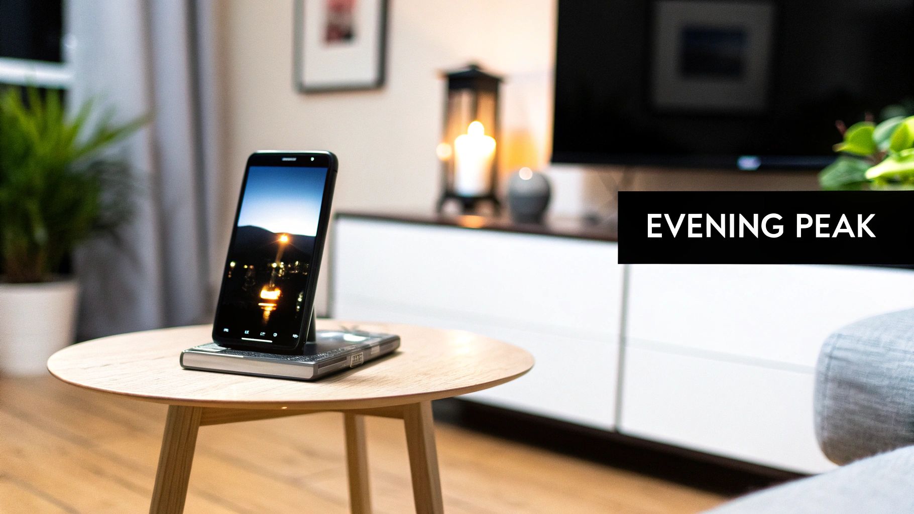 A smartphone on a wooden table displays a captivating evening cityscape with vibrant lights reflecting.