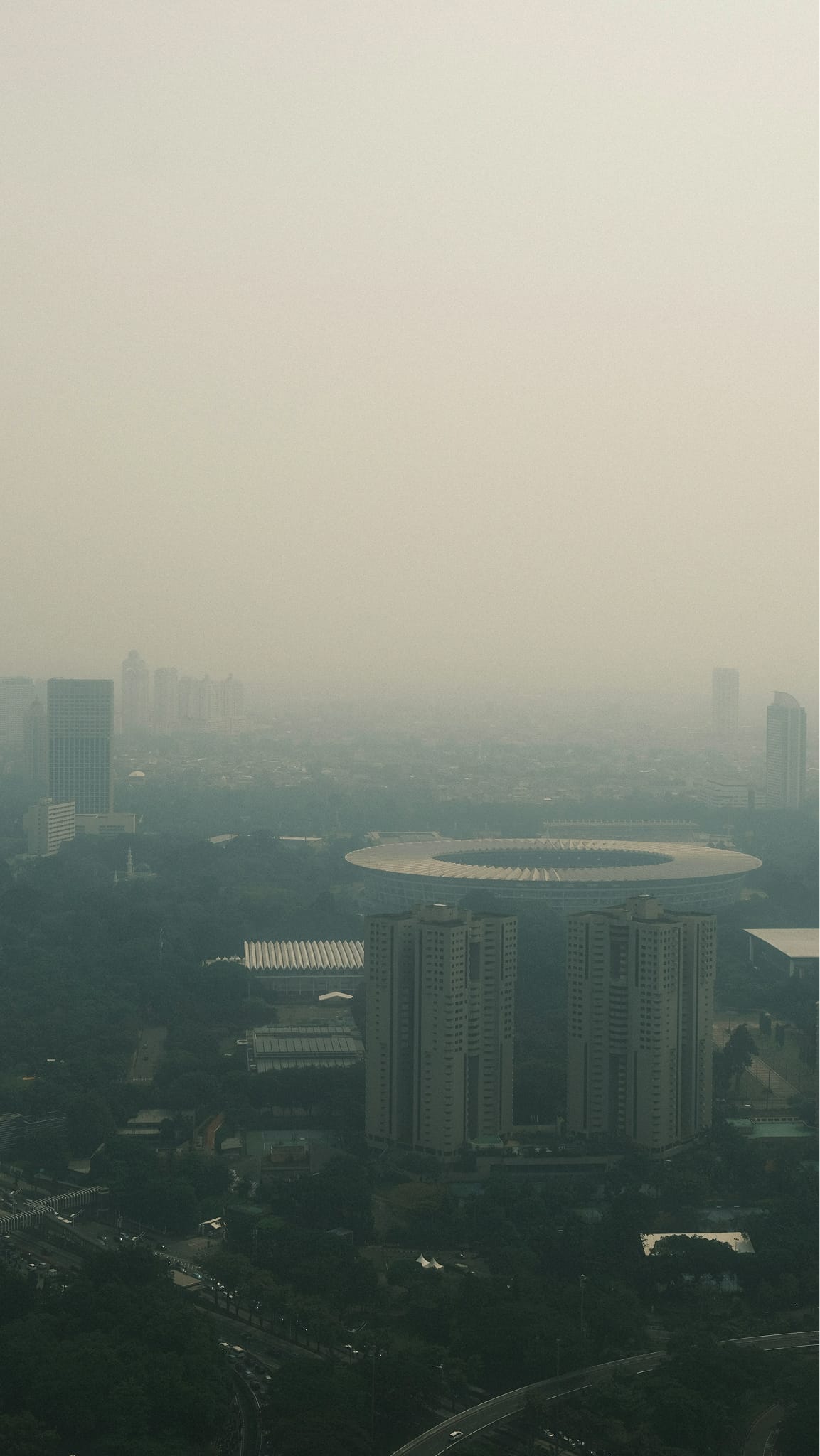 Cityscape shrouded in smog and haze.