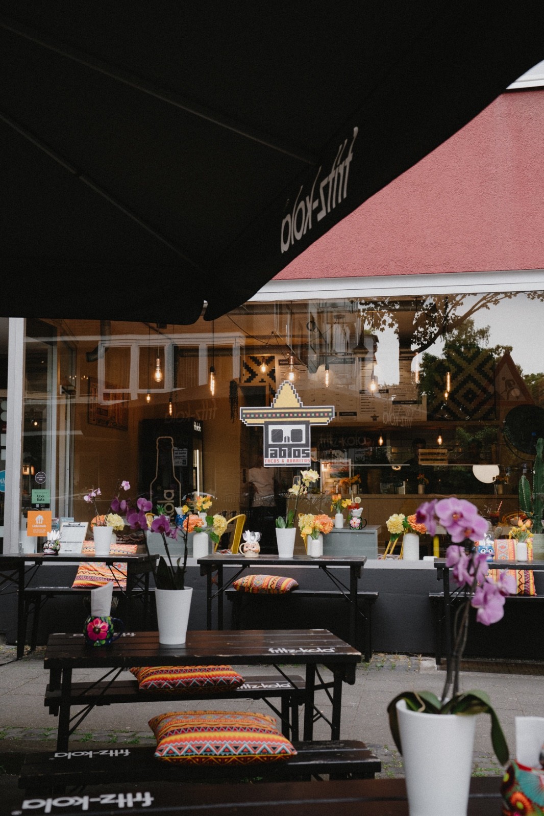 Barista pouring milk into striped ceramic mug