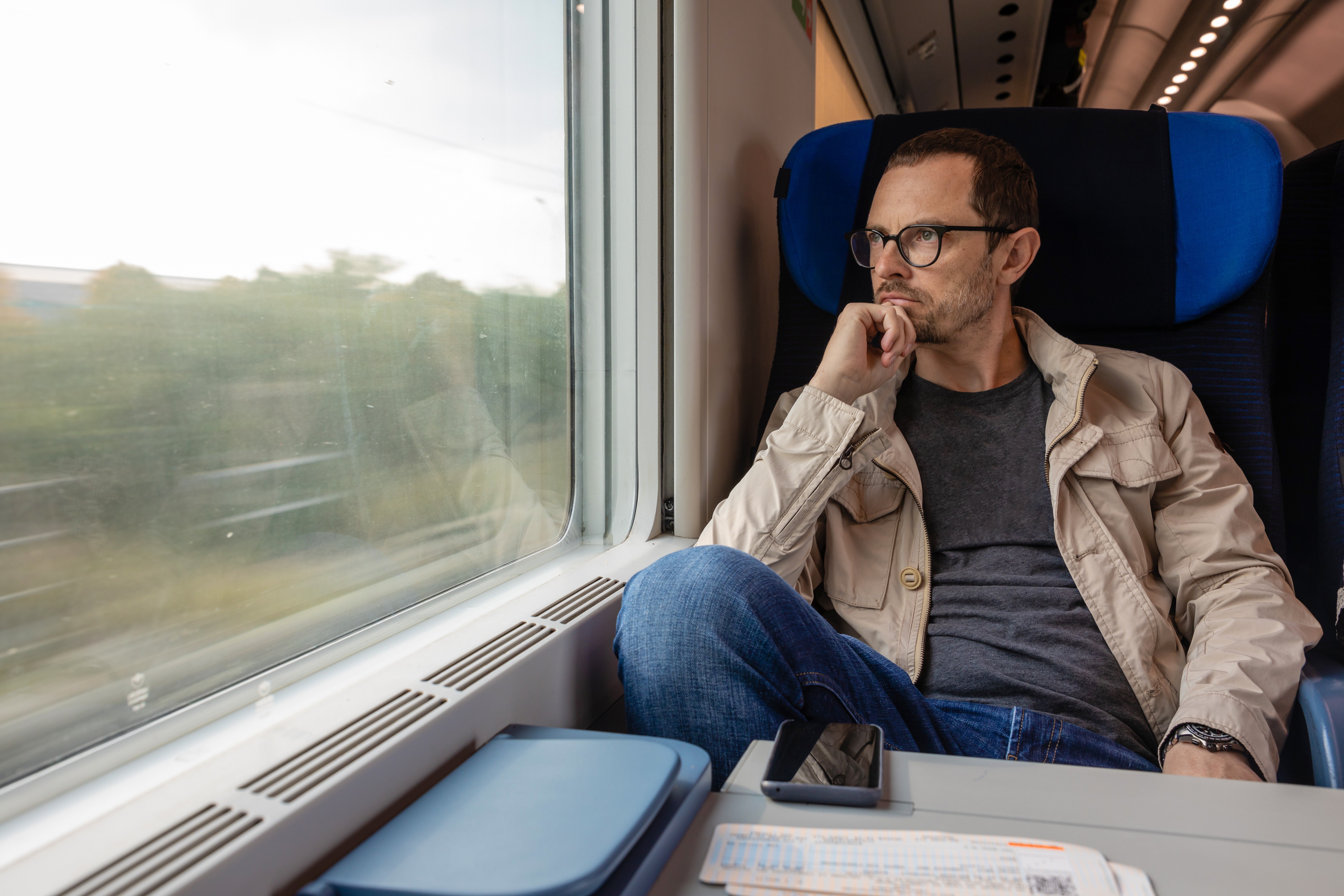 Middle age man looking out of the window of train.