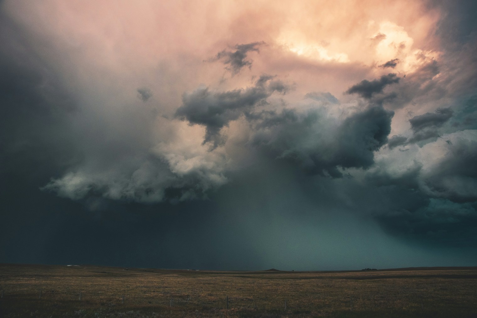 Donkere stormwolken boven een veld