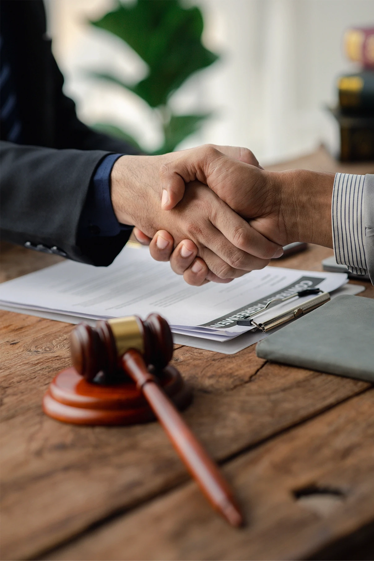 Attorney and client shaking hands above legal documents, illustrating trust and partnership in pursuing a wrongful death claim