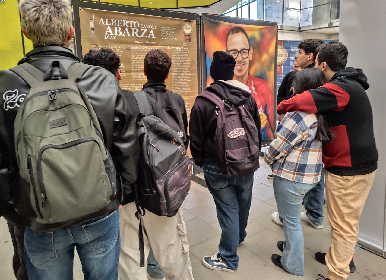 Espectadores admirando la pintura de Alberto Abarza, nadador paralímpico chileno, en la exposición Leyendas del Deporte en USACH.