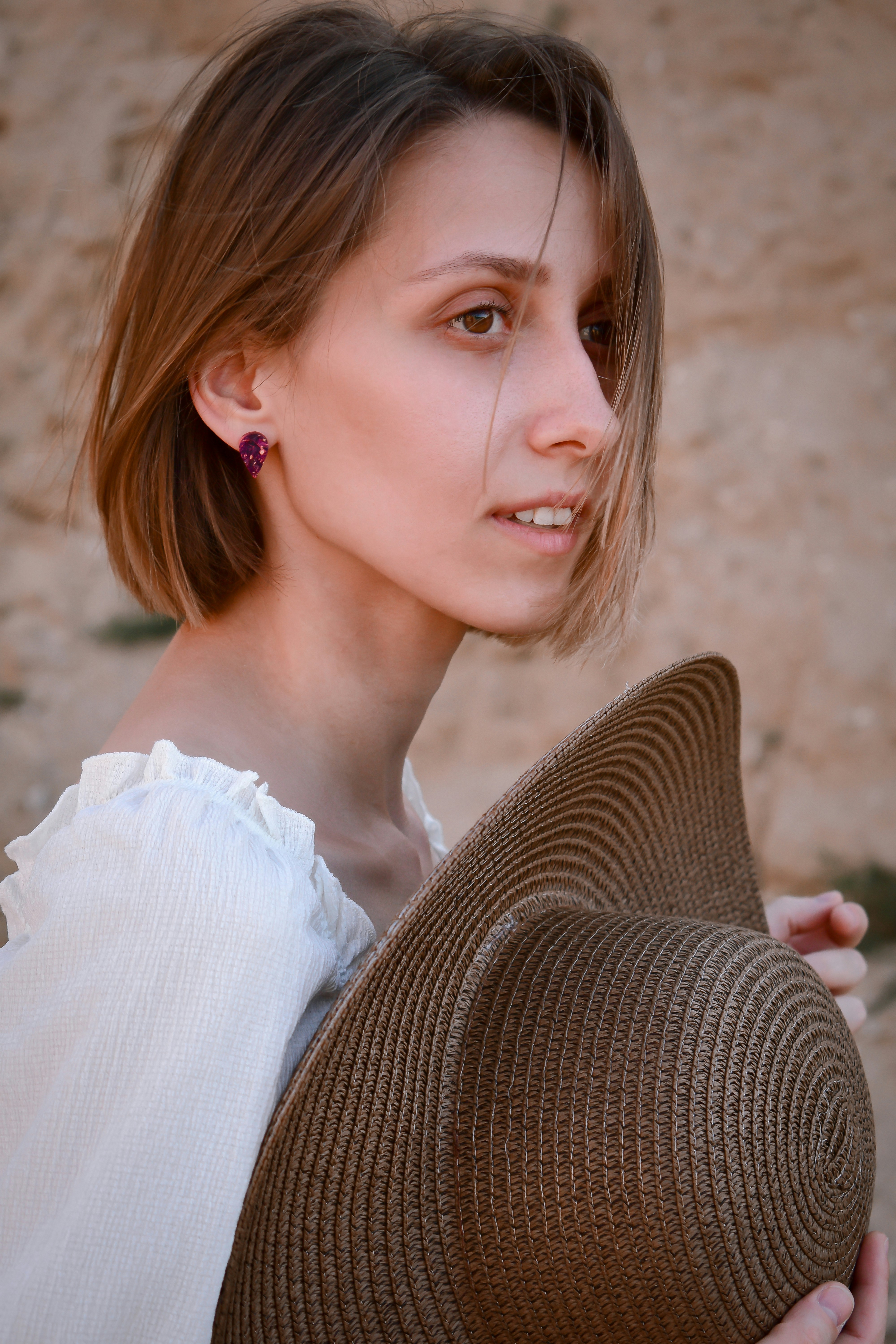 woman in white off shoulder shirt sitting on brown wicker chair