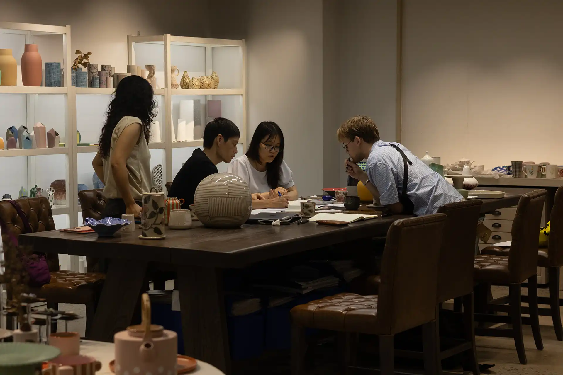 Yannik discussing designs with two producers on a table