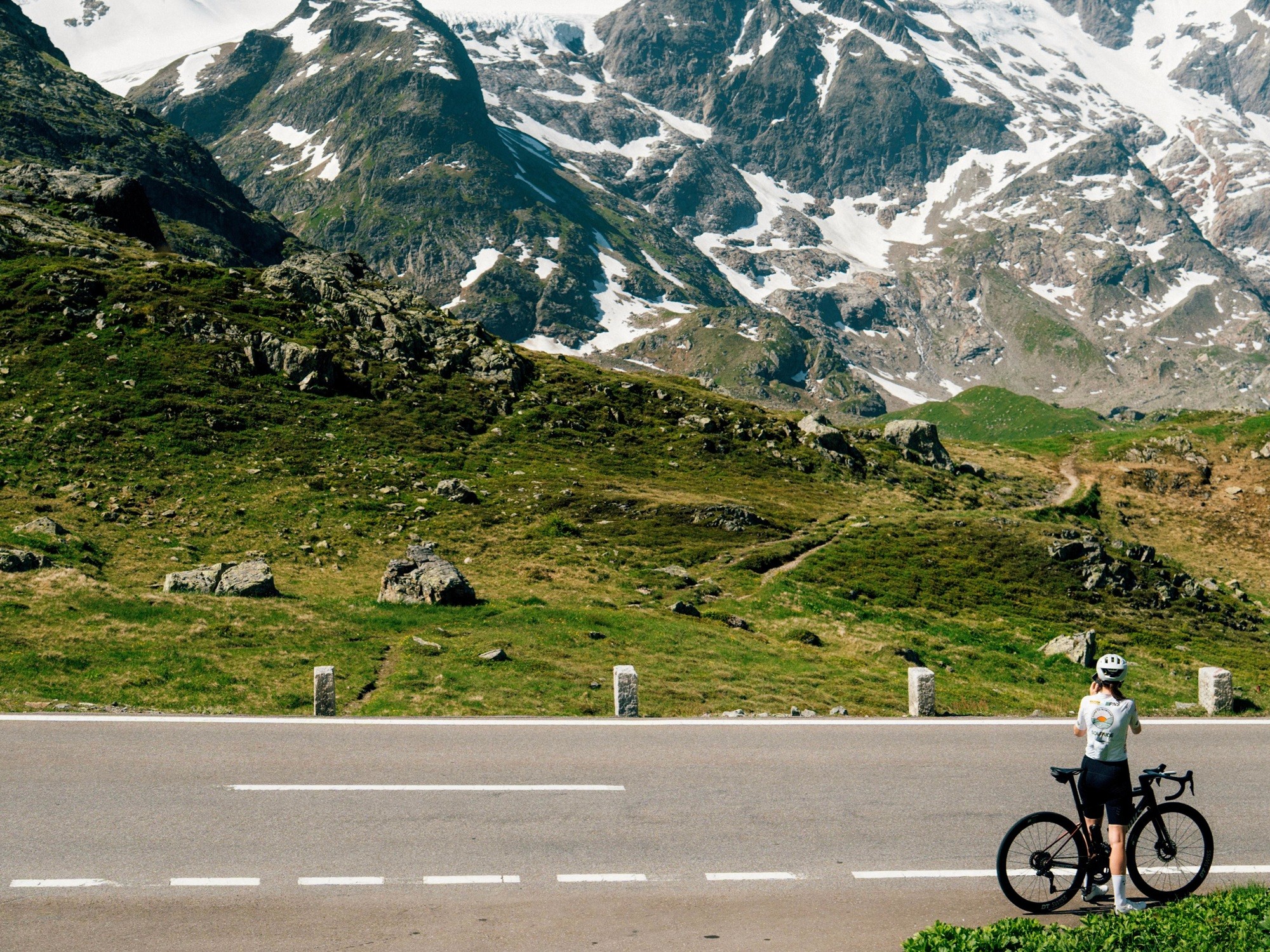 Lone cyclist looking at a view of the Swiss Alps