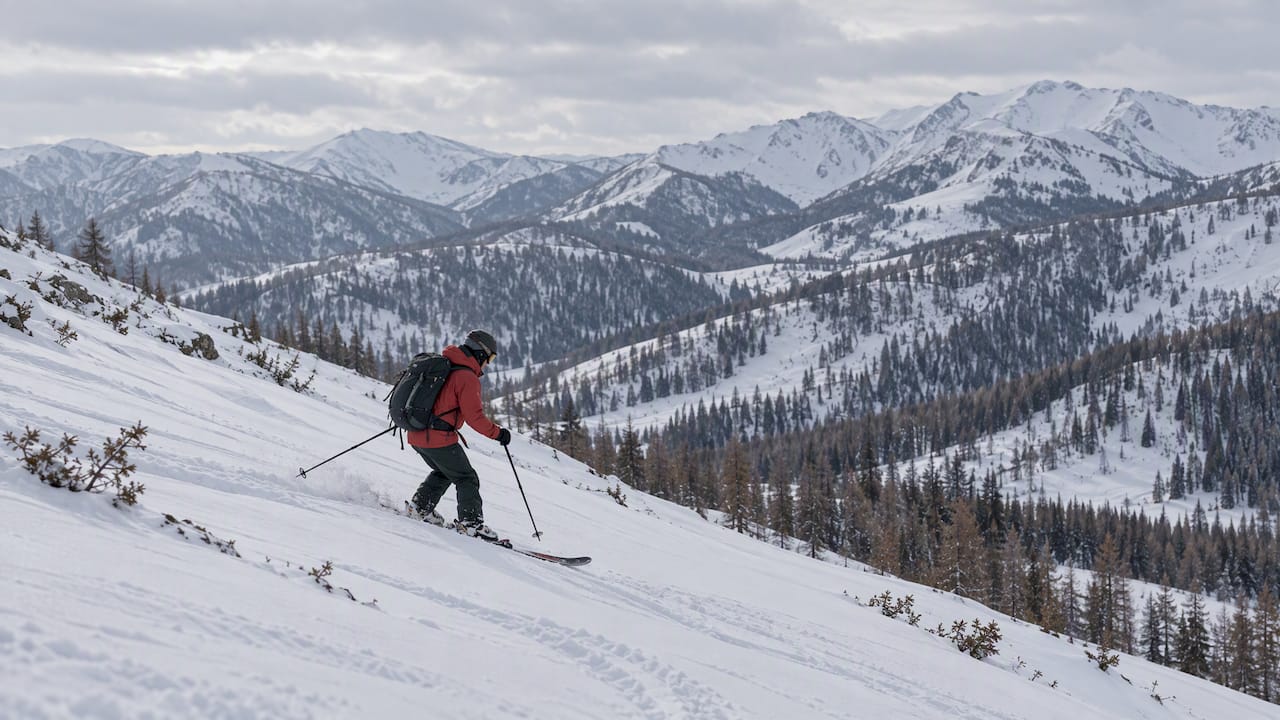 Skier traversing a snow-covered mountain slope