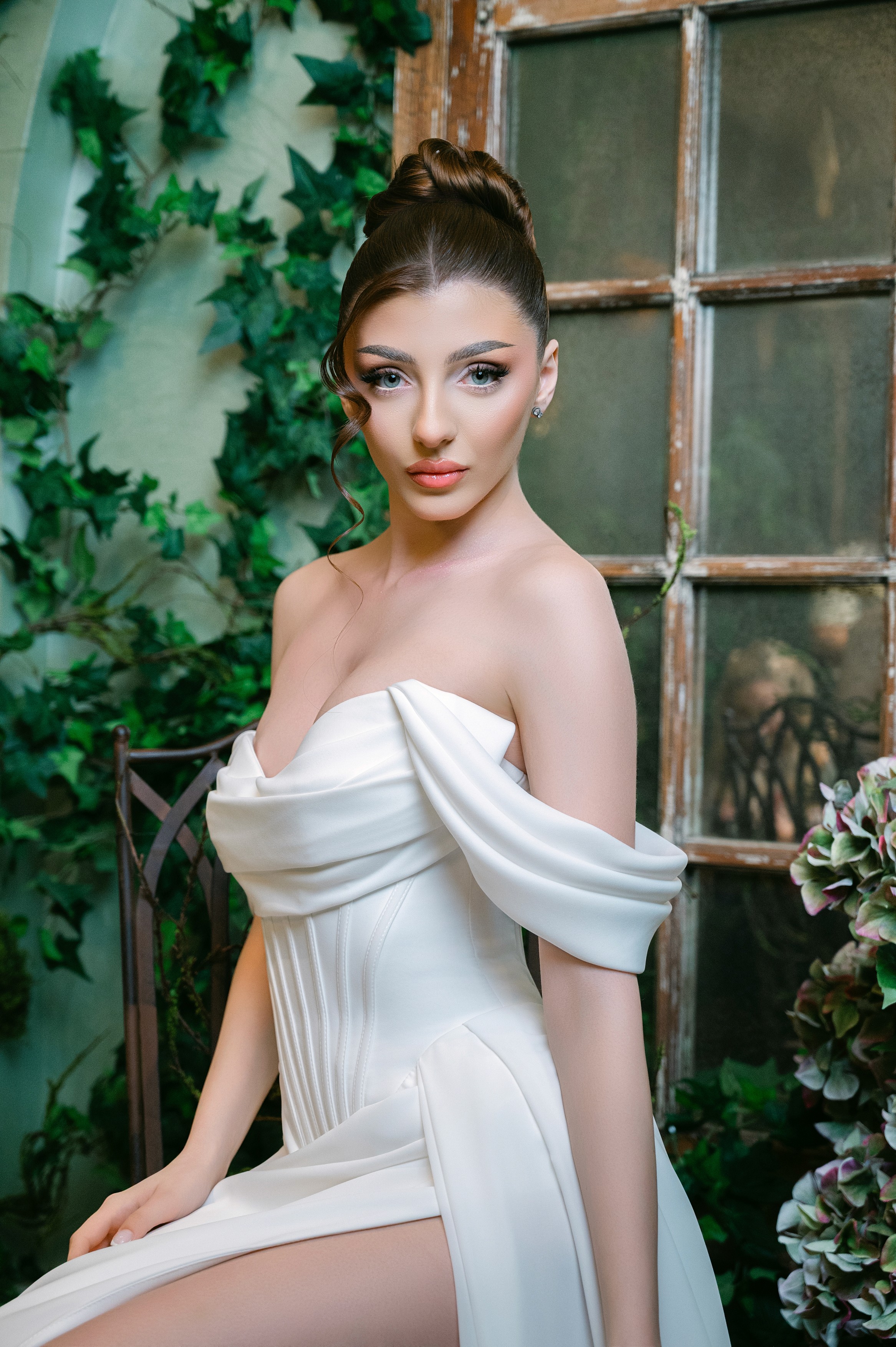 Mireasă fotografiată în fața unei sere cu plante și lumină naturală, ședință foto de nuntă în București