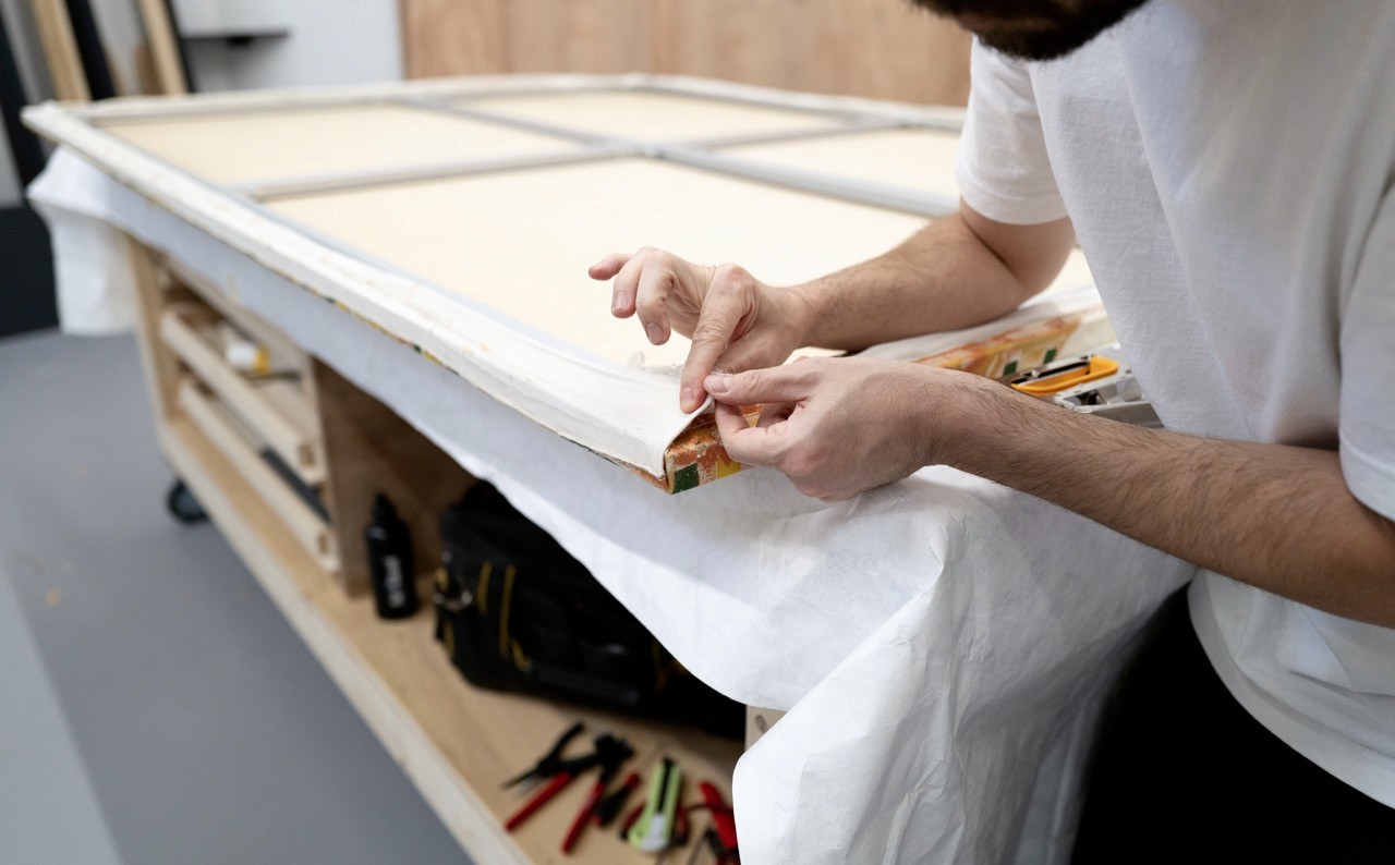 Eythos art technician restretching a canvas