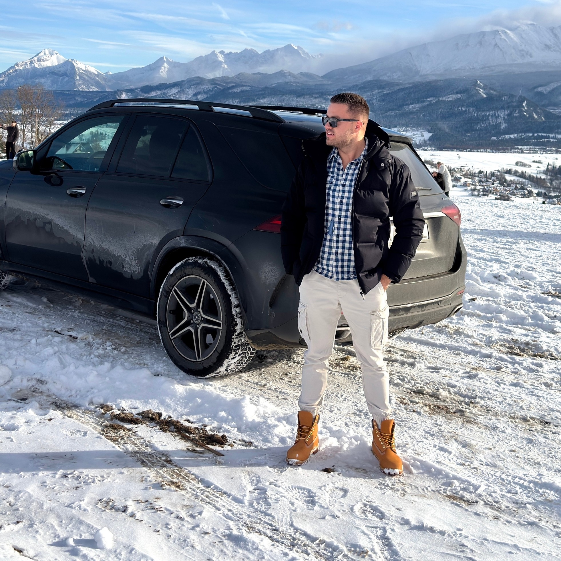 Portrait of a young man with short hair, wearing a dark t-shirt, against a plain background.