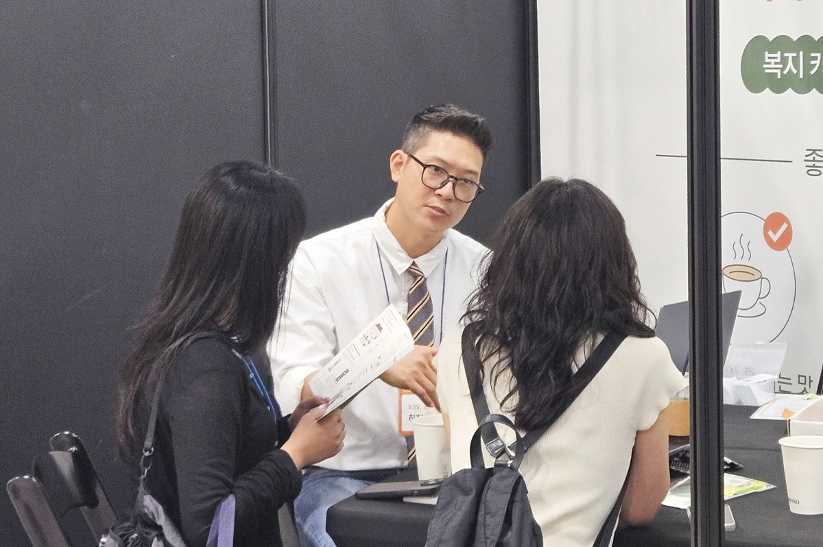 사내카페에 관하여 상담하고 있는 1명의 히즈빈스 직원과 2명의 고객