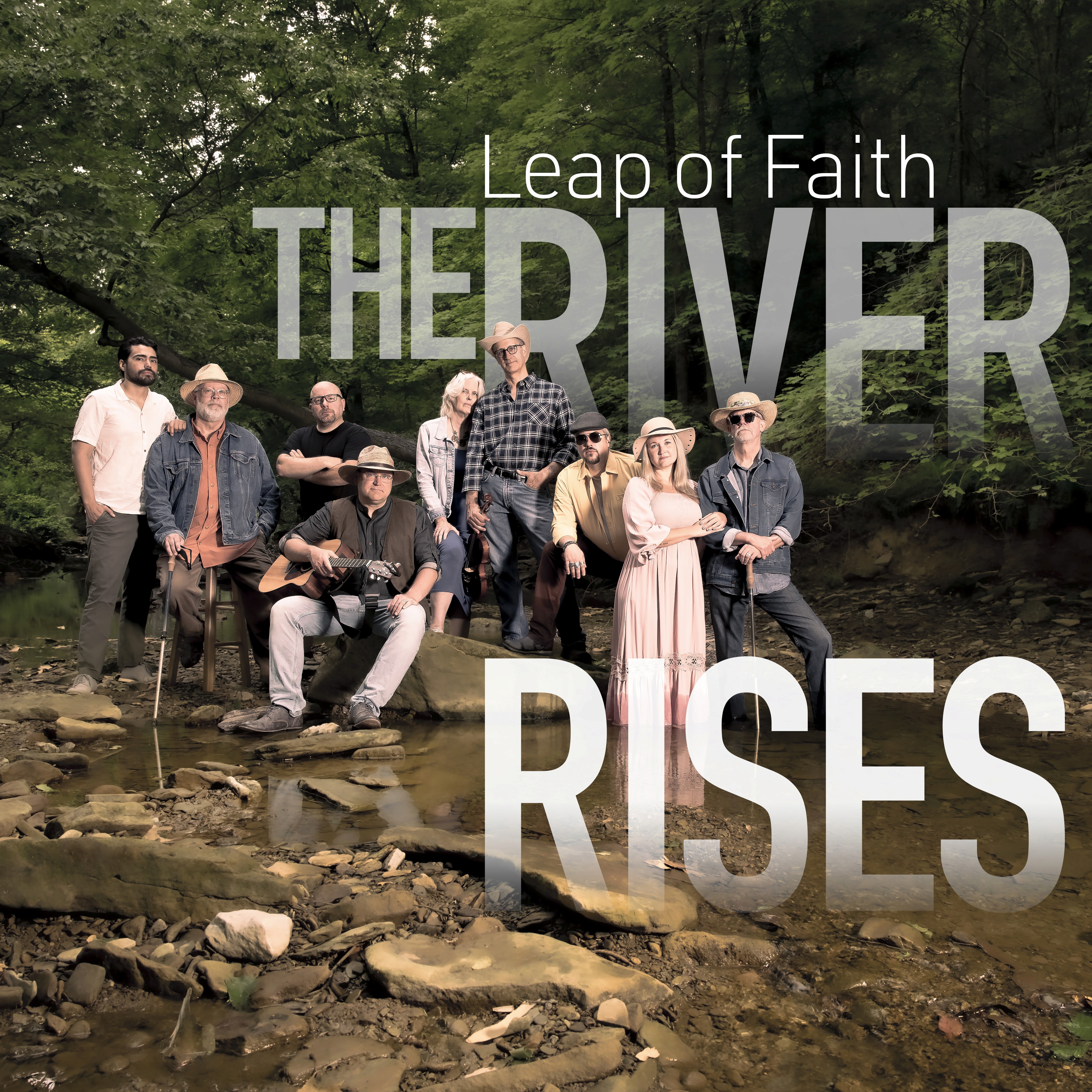 Cover of Leap of Faith's album, The River Rises, featuring the band posed in the middle of a rocky stream running through a forest.
