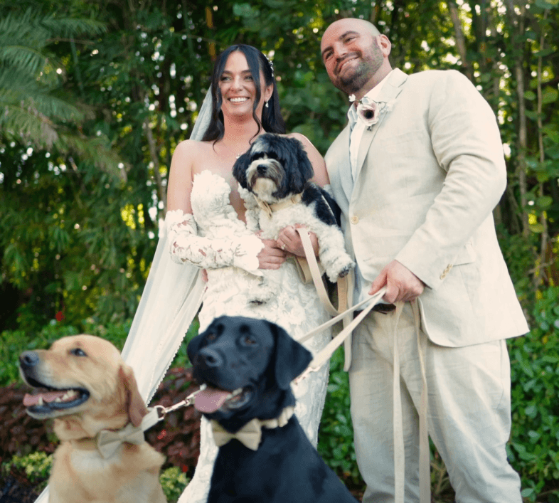 Happy couple just married posing with their 3 dogs